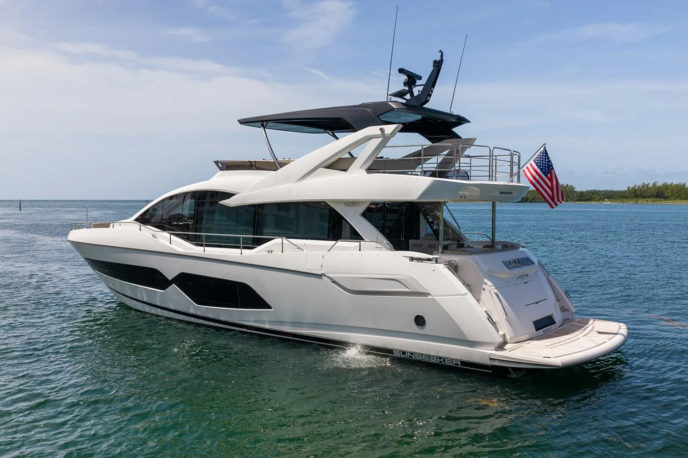 A sleek and modern yacht glides gracefully on the water, showcasing its elegant design and spacious deck areas. aboard BAZINGA Yacht for Sale