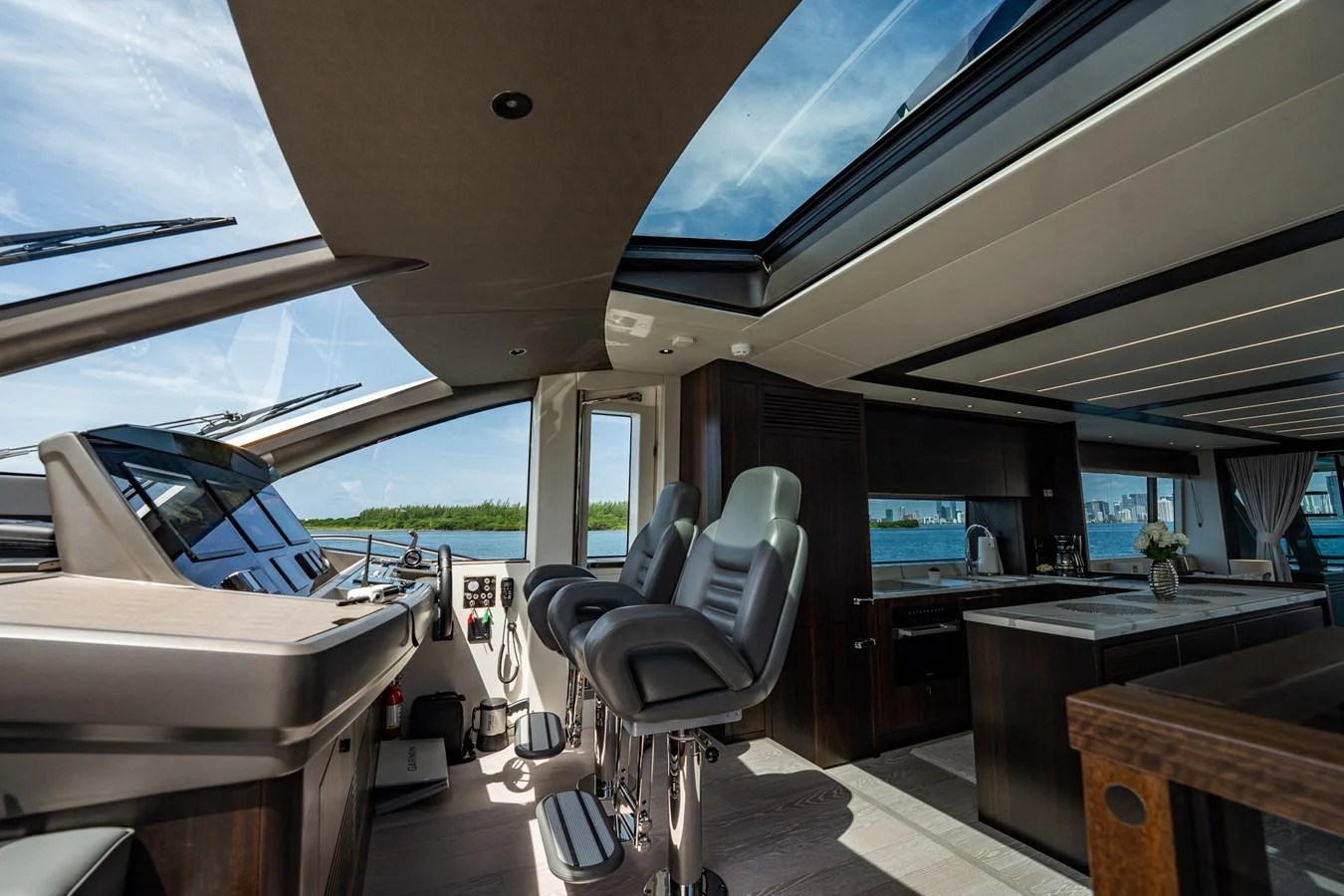 The helm station offers a sleek and modern design with panoramic views and luxurious seating. aboard BAZINGA Yacht for Sale