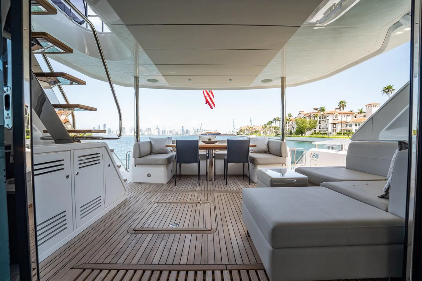 The aft deck features a spacious seating area with a dining table, offering a perfect spot for alfresco dining with a view. aboard BAZINGA Yacht for Sale