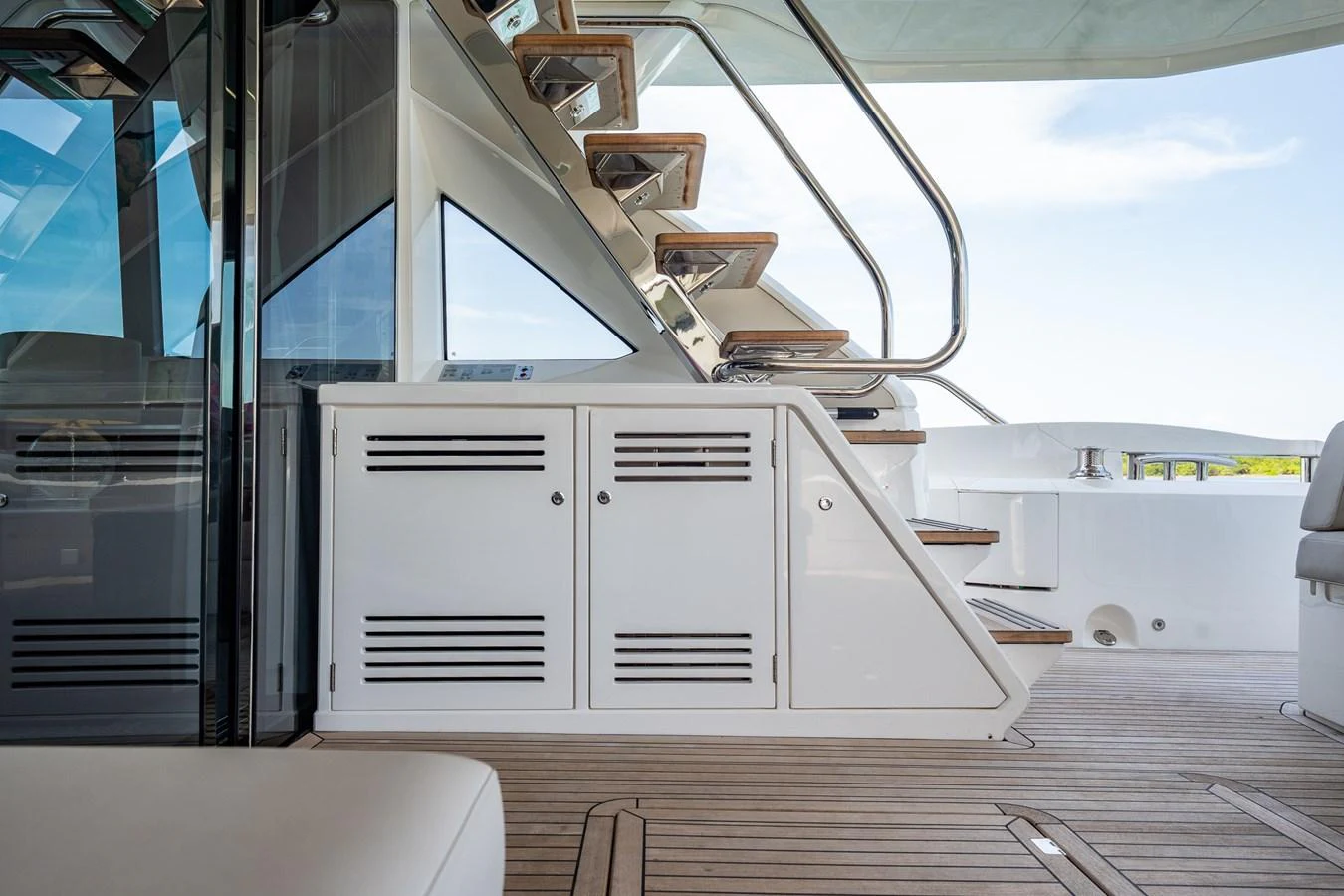 The aft deck features sleek stairs leading to the upper deck, complemented by polished wood and stainless steel accents. aboard BAZINGA Yacht for Sale