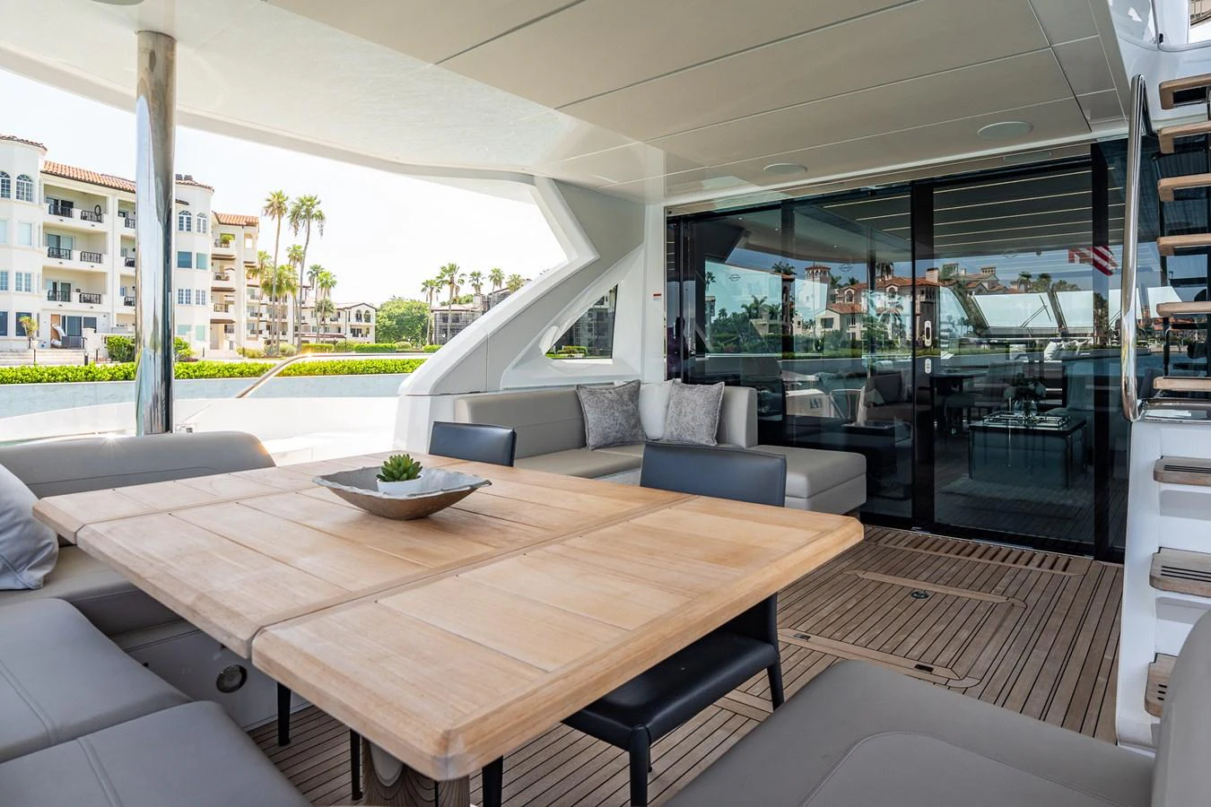 The aft deck features a spacious seating area with a wooden table, perfect for alfresco dining and relaxation. aboard BAZINGA Yacht for Sale
