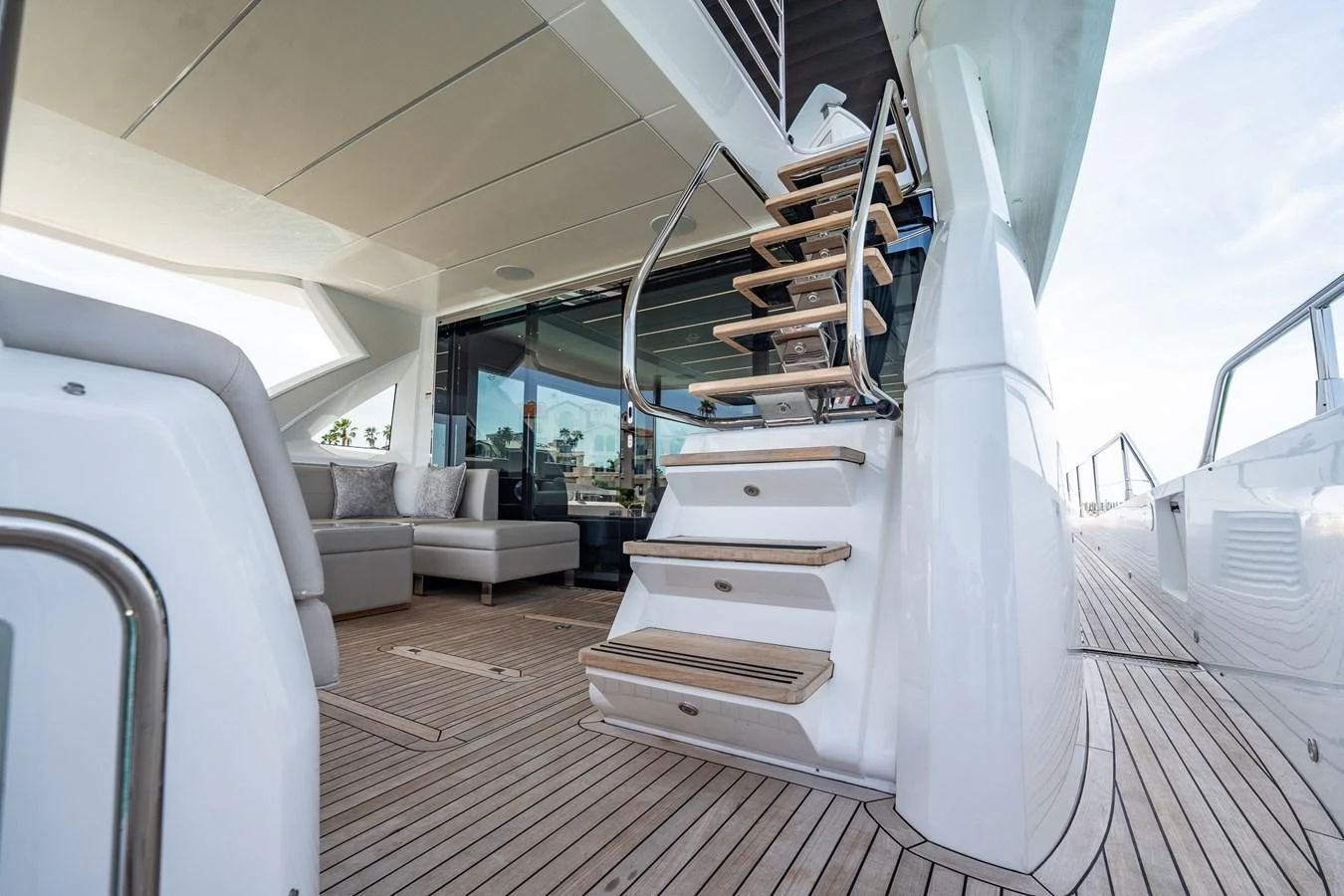 The aft deck features a stylish staircase leading to the upper deck, complemented by a comfortable seating area. aboard BAZINGA Yacht for Sale