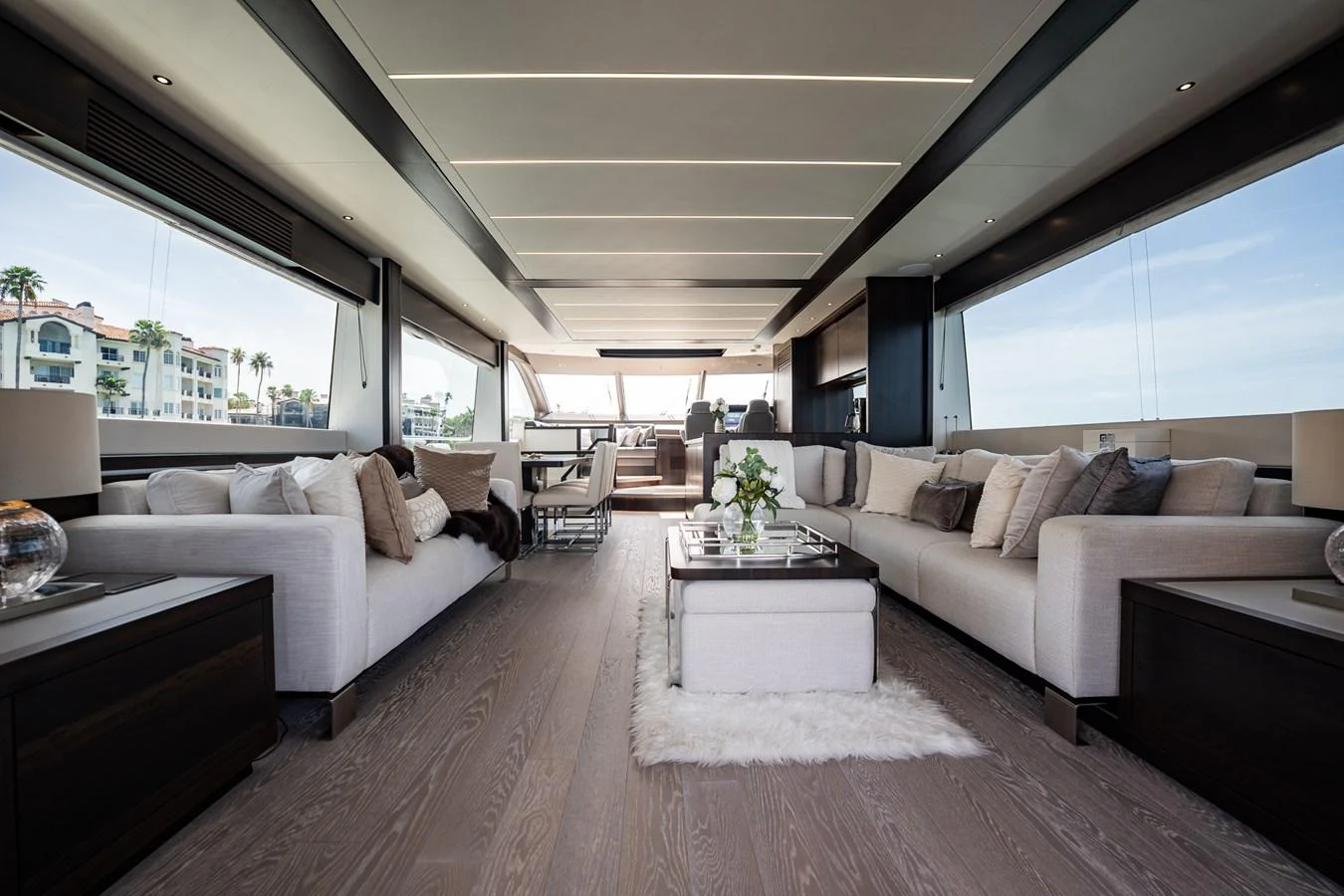 The salon features elegant seating with panoramic windows offering stunning views. aboard BAZINGA Yacht for Sale