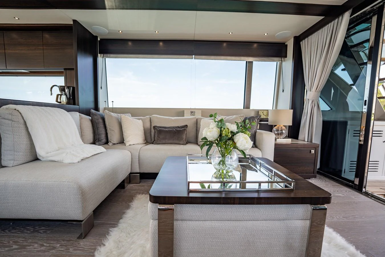 The salon features a luxurious seating area with elegant decor and large windows offering stunning views. aboard BAZINGA Yacht for Sale