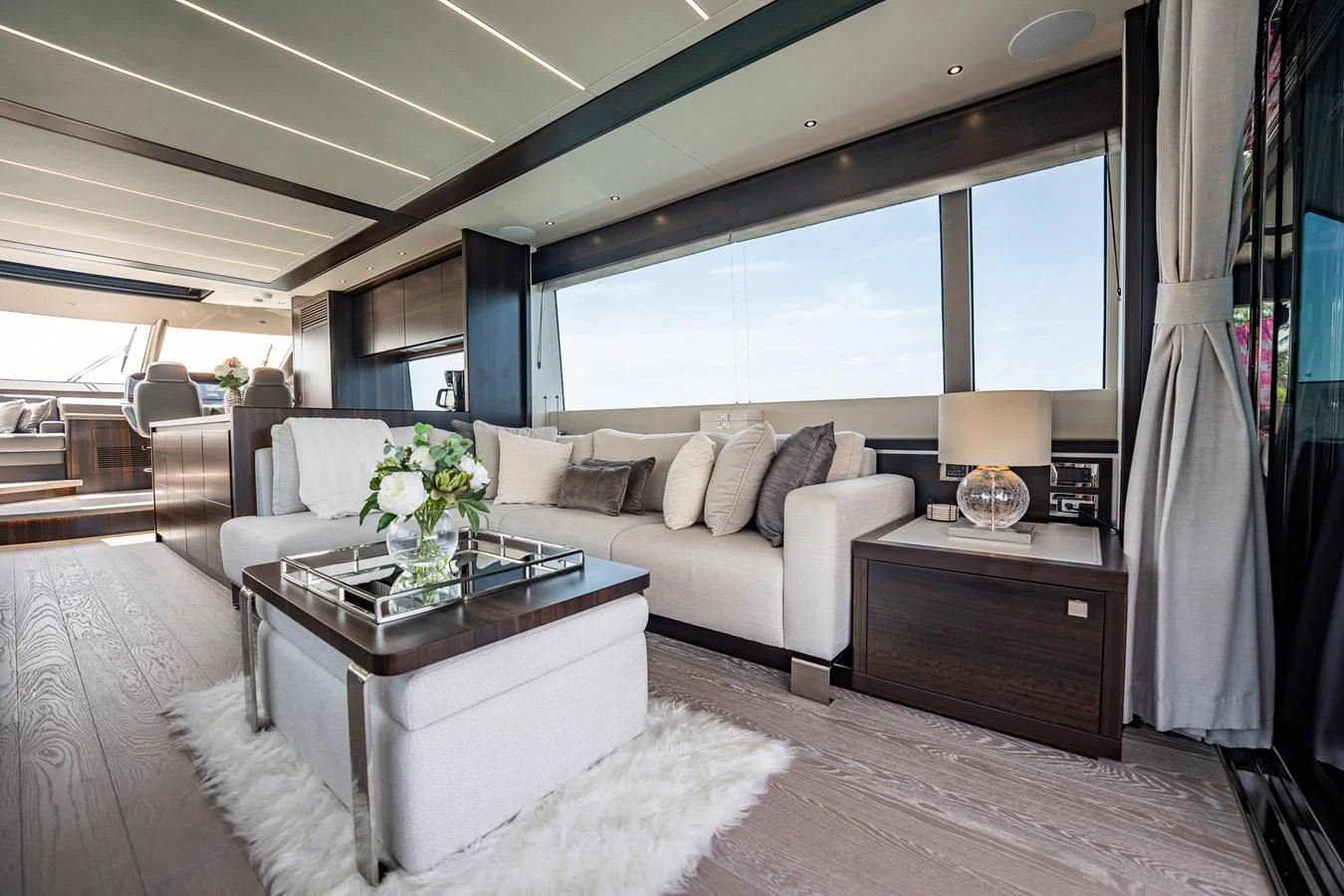 The salon features a luxurious seating area with elegant decor and expansive windows offering stunning views. aboard BAZINGA Yacht for Sale