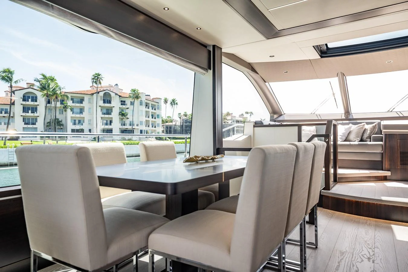 The yacht's dining area features elegant seating with a view of the water and surrounding buildings. aboard BAZINGA Yacht for Sale