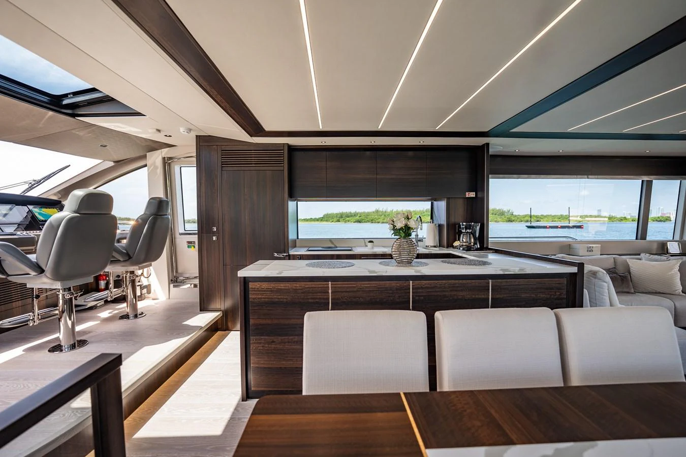 The salon features modern furnishings with ample natural light and a view of the helm station. aboard BAZINGA Yacht for Sale