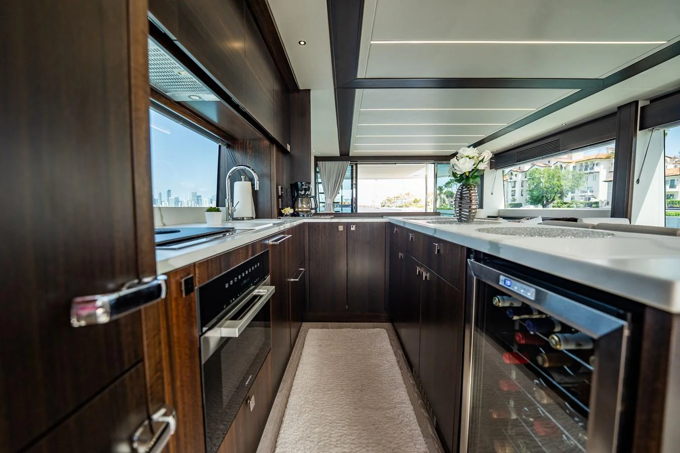 The yacht's galley features modern appliances and sleek dark wood cabinetry, creating a sophisticated culinary space. aboard BAZINGA Yacht for Sale