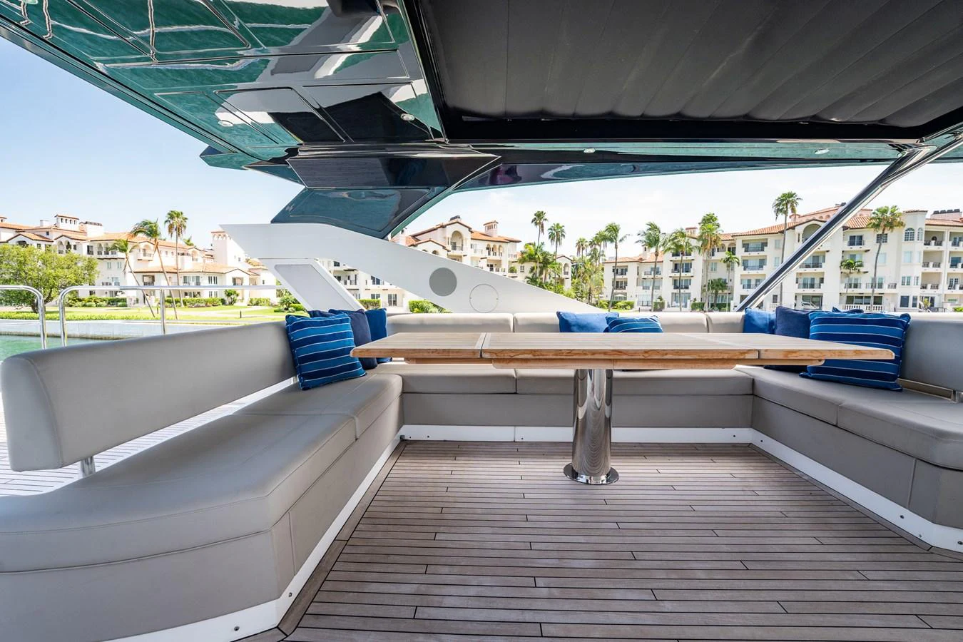 The aft deck features a spacious seating area with a wooden table, perfect for outdoor relaxation and dining. aboard BAZINGA Yacht for Sale