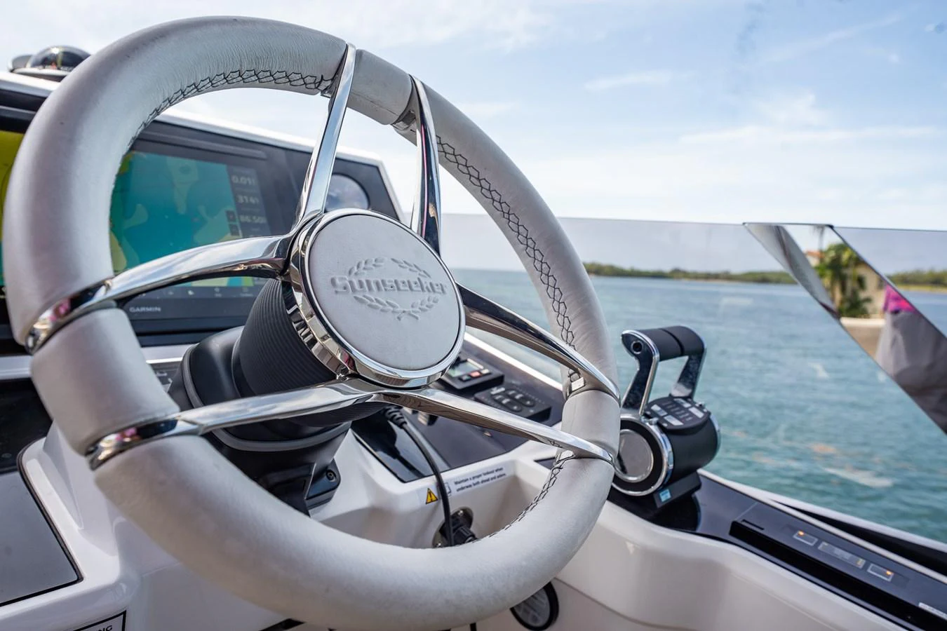 A sleek and modern helm station with advanced navigation controls and a polished steering wheel. aboard BAZINGA Yacht for Sale