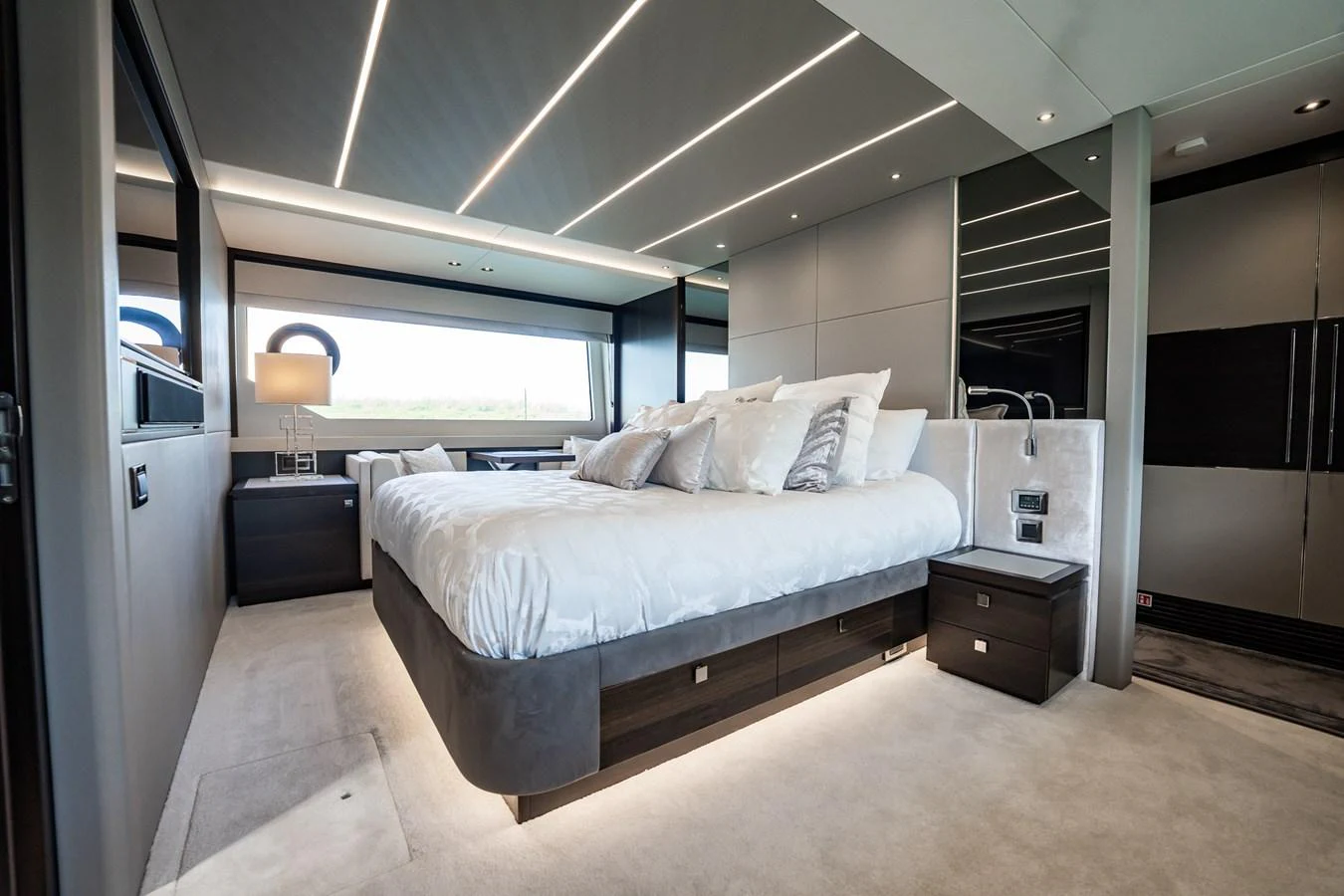 The master stateroom features a luxurious bed with modern lighting and sleek furnishings. aboard BAZINGA Yacht for Sale