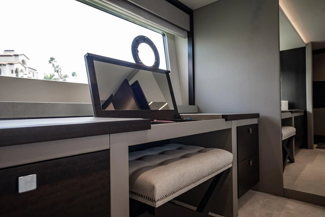 This image showcases a sleek vanity area with a modern design and ample natural light. aboard BAZINGA Yacht for Sale