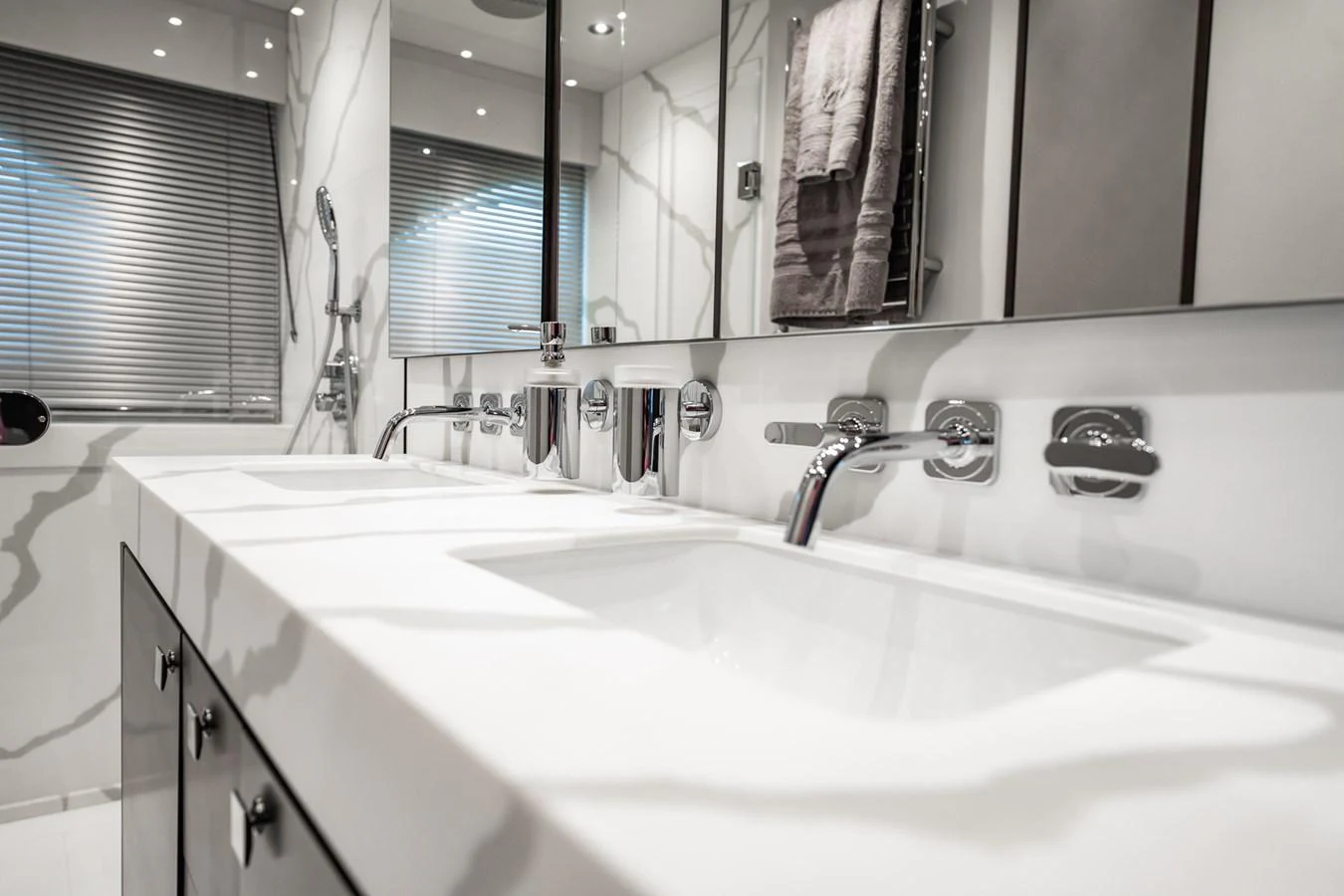 A sleek and modern yacht bathroom with elegant fixtures and a spacious countertop. aboard BAZINGA Yacht for Sale