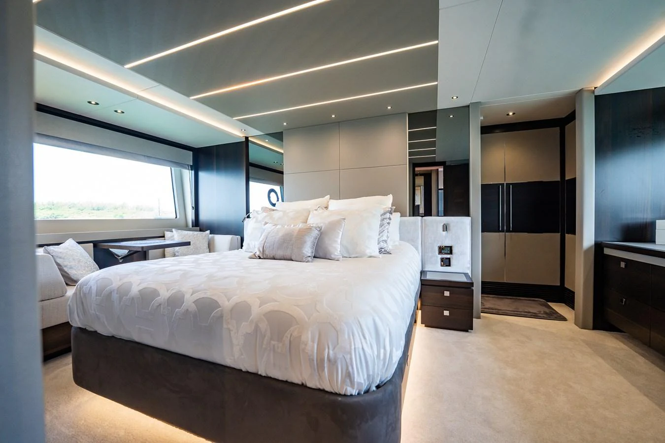 The master stateroom features a luxurious bed with elegant decor and ample natural light. aboard BAZINGA Yacht for Sale