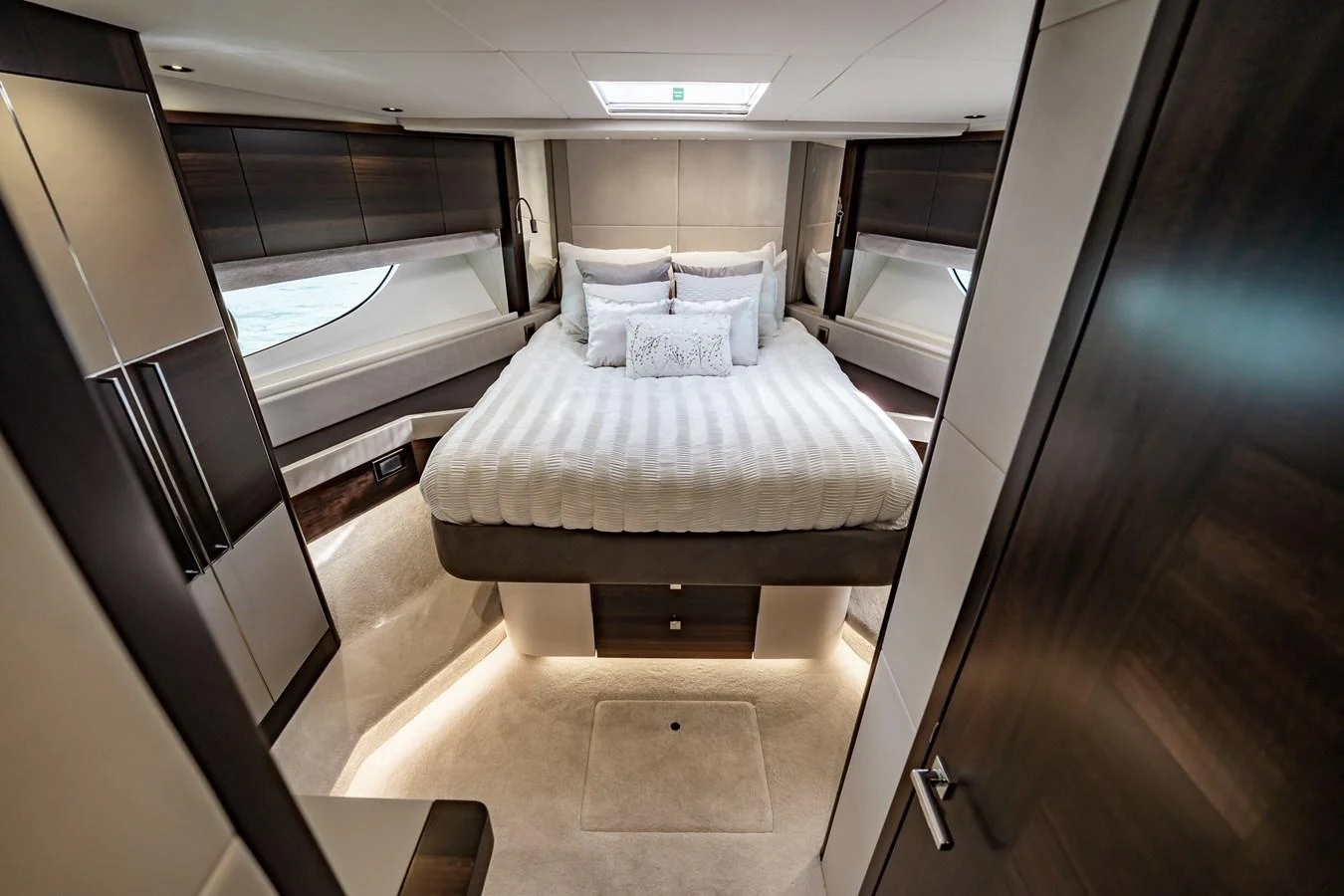 The master stateroom features a luxurious bed with elegant bedding and ample natural light. aboard BAZINGA Yacht for Sale