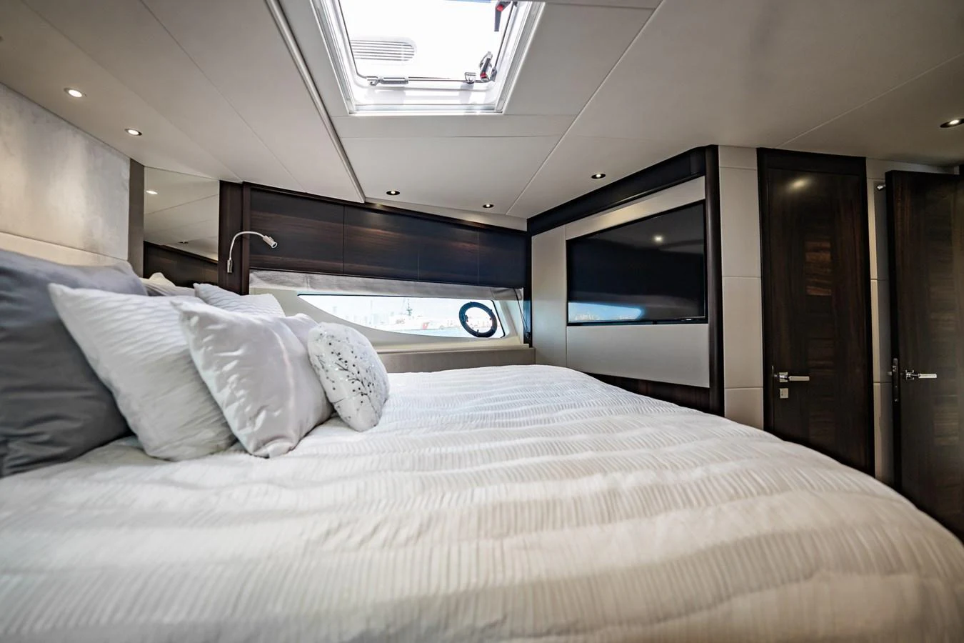 A luxurious stateroom featuring a large bed and modern decor. aboard BAZINGA Yacht for Sale