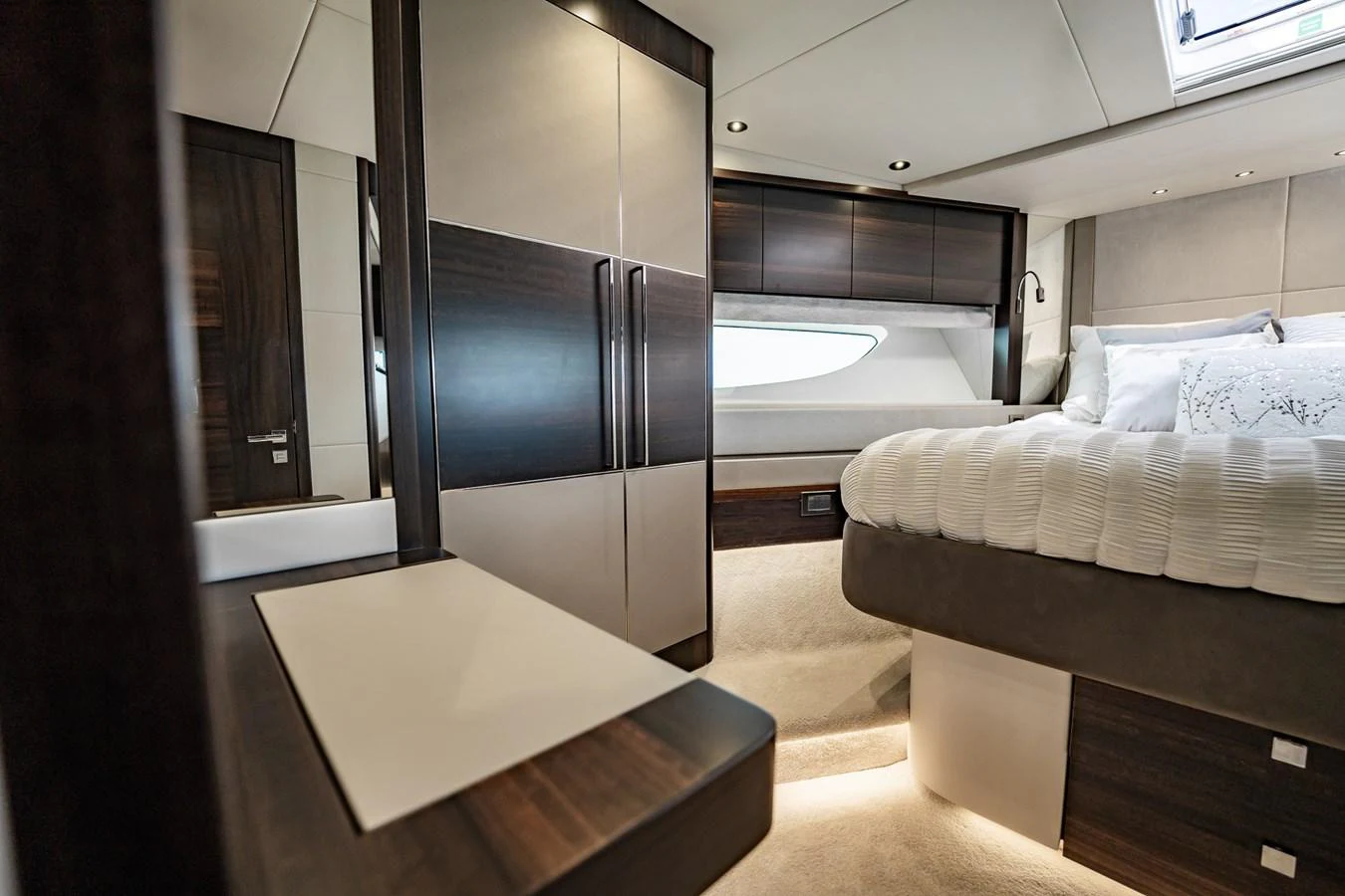 The stateroom features a luxurious bed, modern cabinetry, and elegant lighting. aboard BAZINGA Yacht for Sale