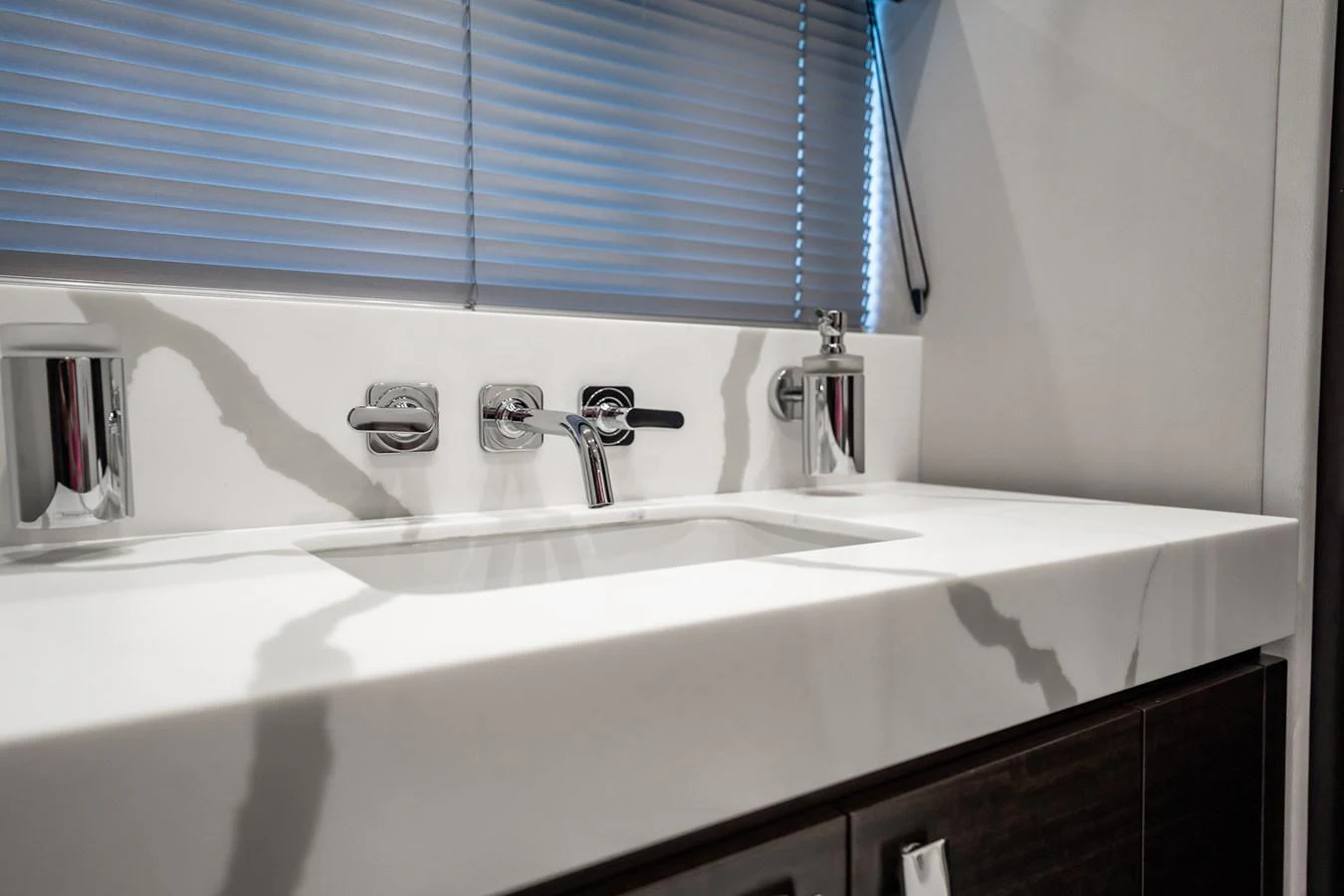 A sleek and modern bathroom with a marble countertop and contemporary fixtures. aboard BAZINGA Yacht for Sale