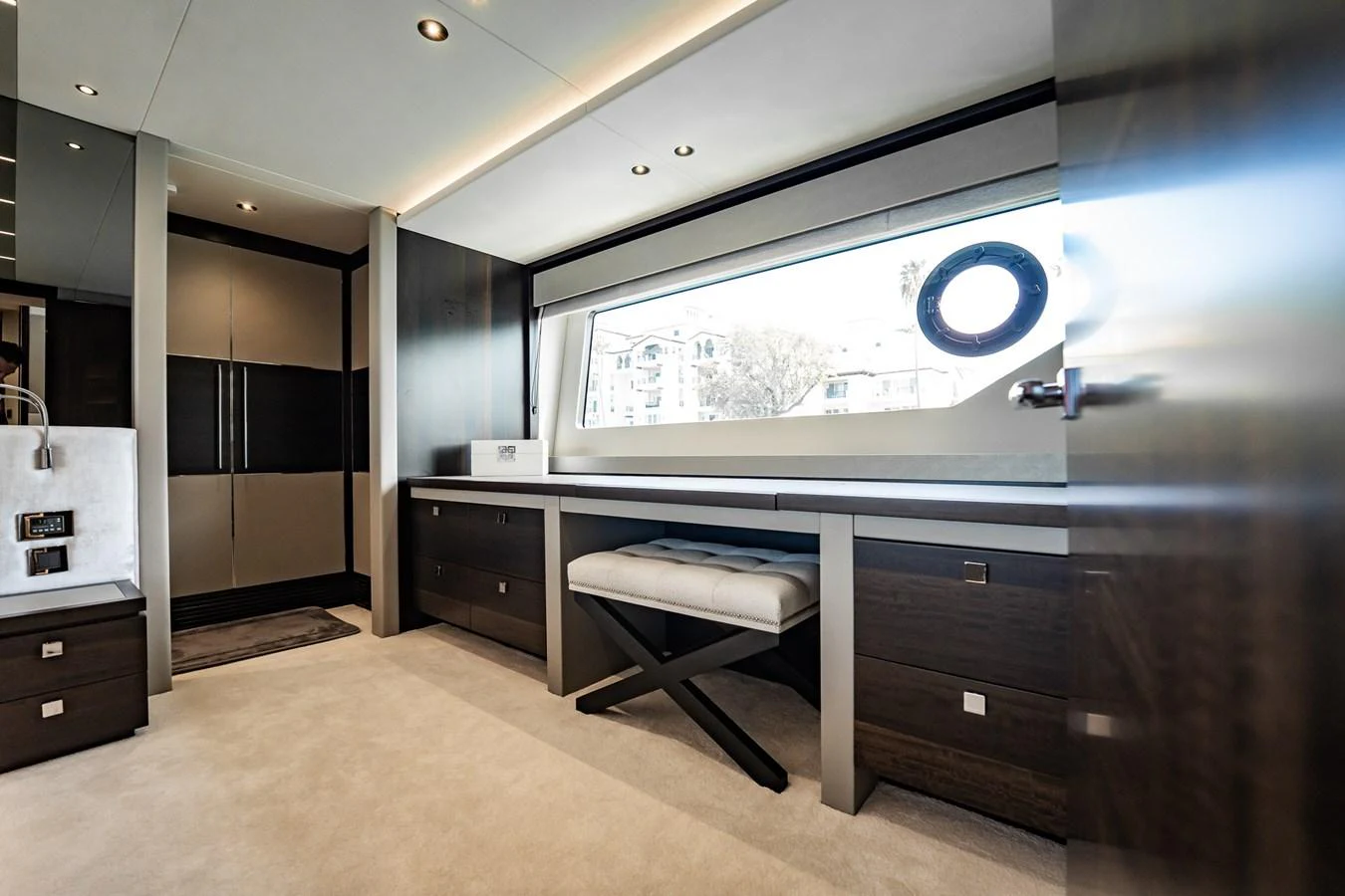 A luxurious yacht interior featuring modern furnishings and a large window with a view. aboard BAZINGA Yacht for Sale
