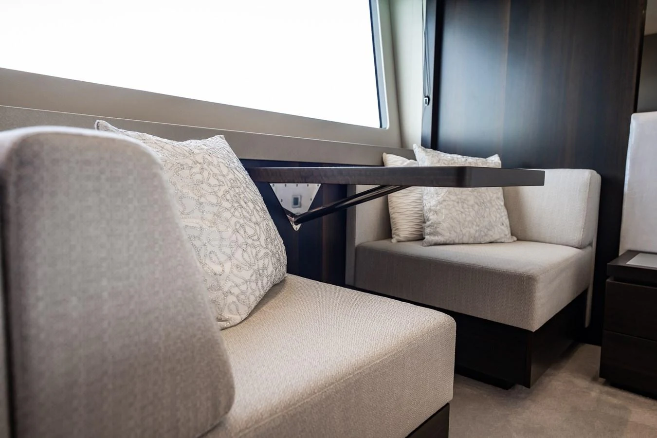 The yacht's interior features a cozy seating area with plush cushions and a sleek table. aboard BAZINGA Yacht for Sale