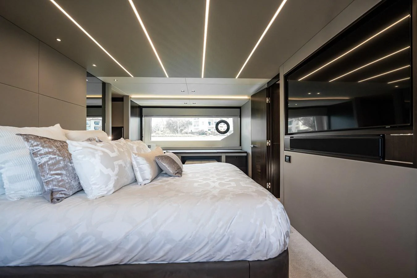 The stateroom features a luxurious bed with elegant bedding and modern lighting. aboard BAZINGA Yacht for Sale