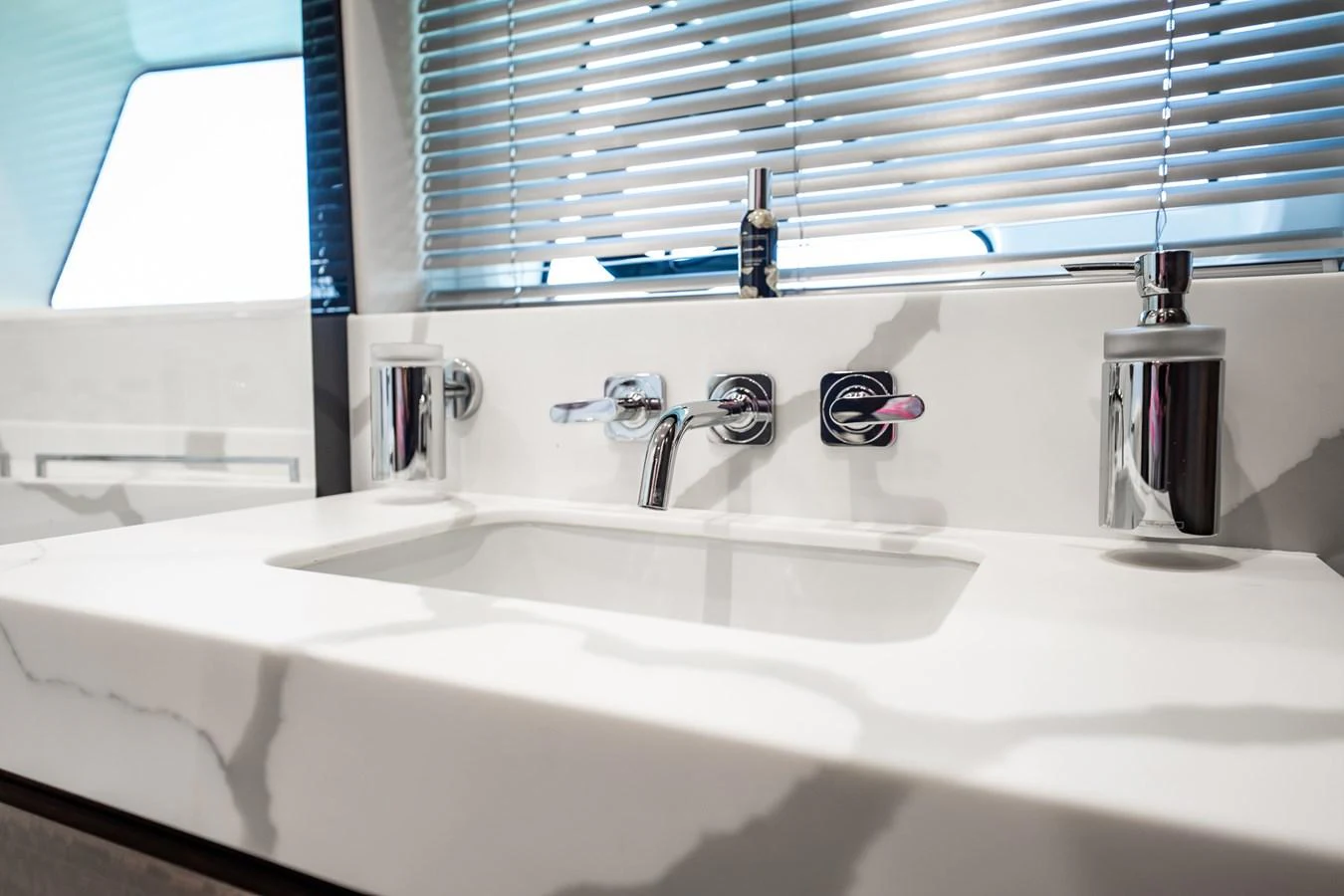 A sleek and modern bathroom sink area with a marble countertop and stylish fixtures. aboard BAZINGA Yacht for Sale