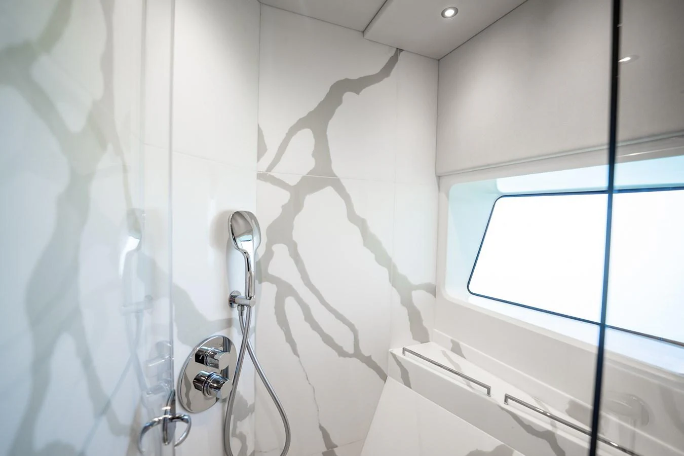 The yacht's bathroom features modern fixtures and a sleek design with a large window for natural light. aboard BAZINGA Yacht for Sale