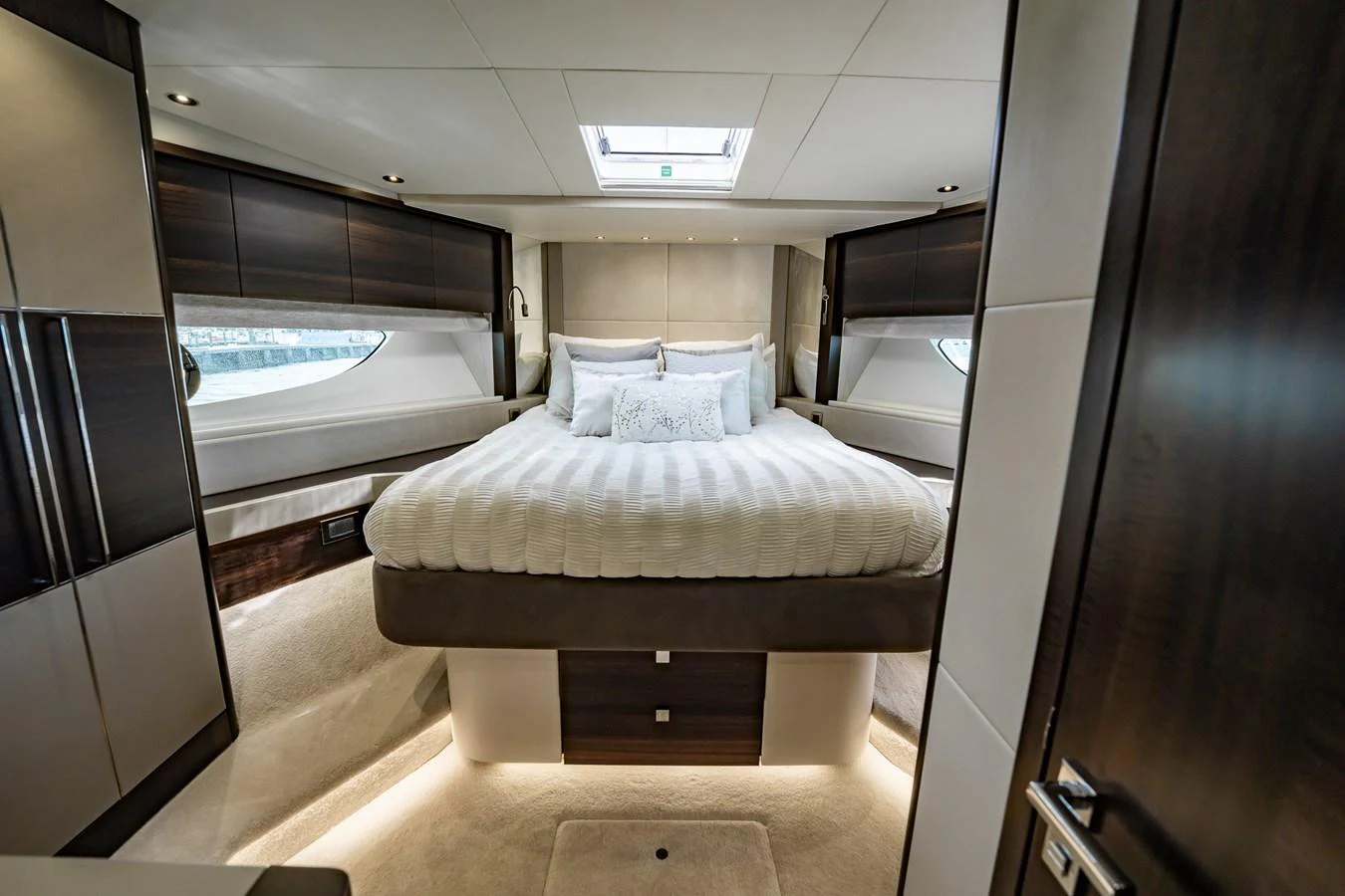 The master stateroom features a luxurious bed with elegant bedding and ample natural light. aboard BAZINGA Yacht for Sale