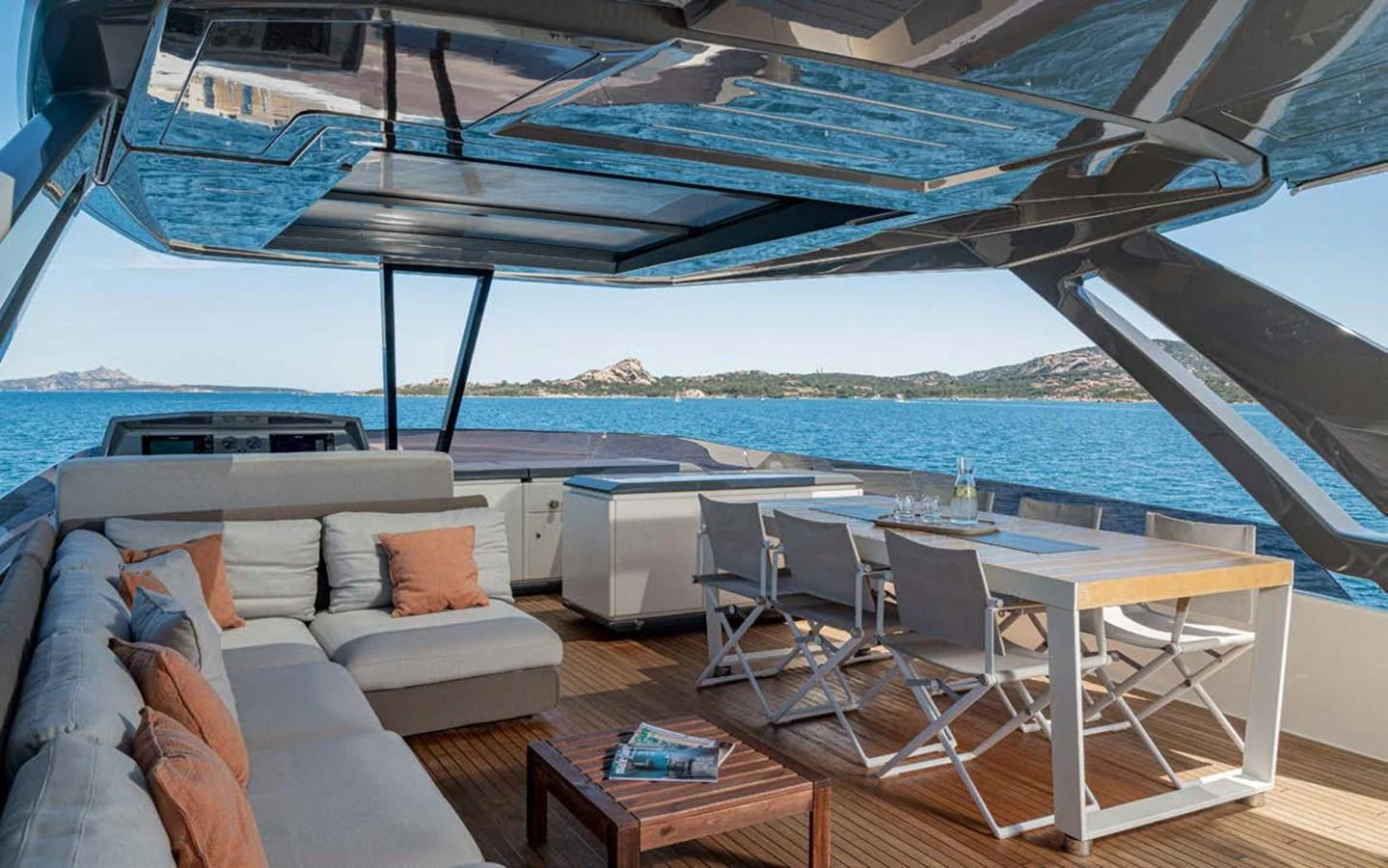 The aft deck features a spacious seating area with a dining table, offering stunning views of the surrounding waters. aboard E3 Yacht for Sale