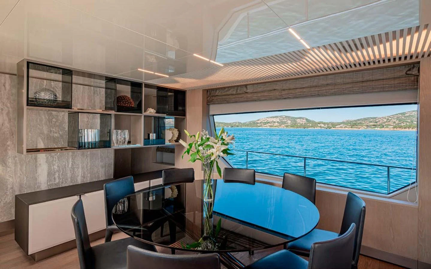 The yacht's dining area features a sleek, modern design with a large window offering stunning sea views. aboard E3 Yacht for Sale