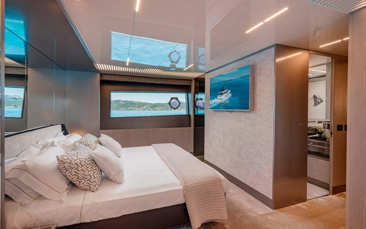 The stateroom features a luxurious bed with elegant decor and a view of the sea through the windows. aboard E3 Yacht for Sale