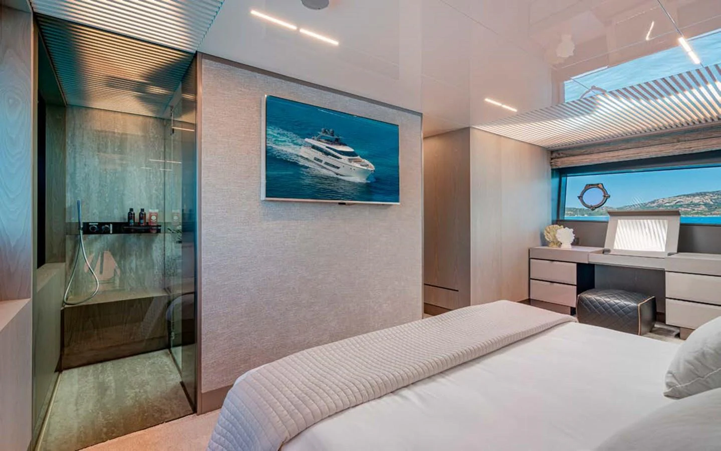 The stateroom features a luxurious bed, a sleek desk area, and a modern en-suite bathroom. aboard E3 Yacht for Sale