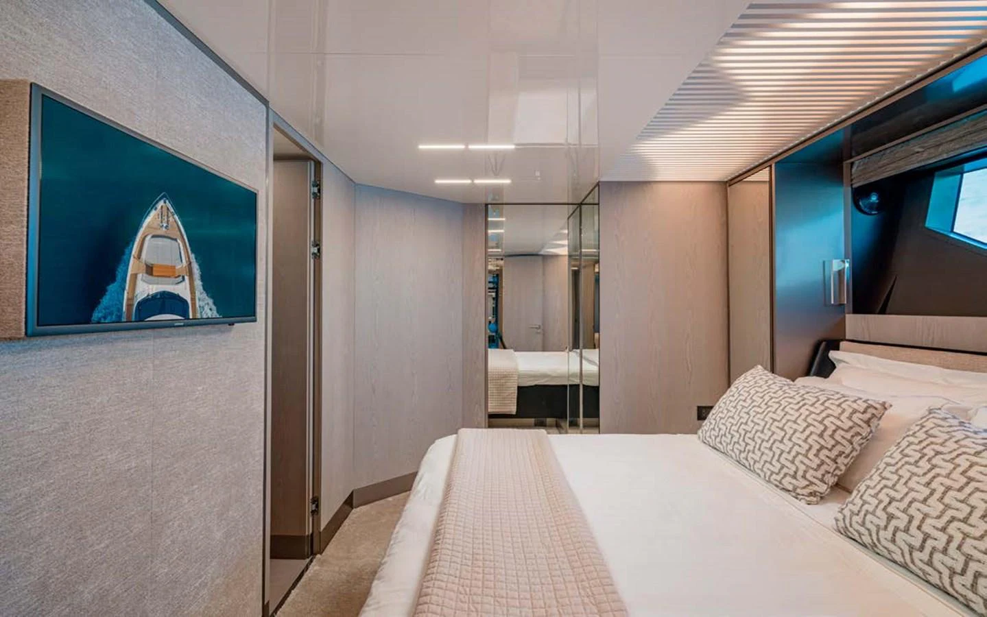 A luxurious stateroom featuring a comfortable bed, modern decor, and a wall-mounted television. aboard E3 Yacht for Sale
