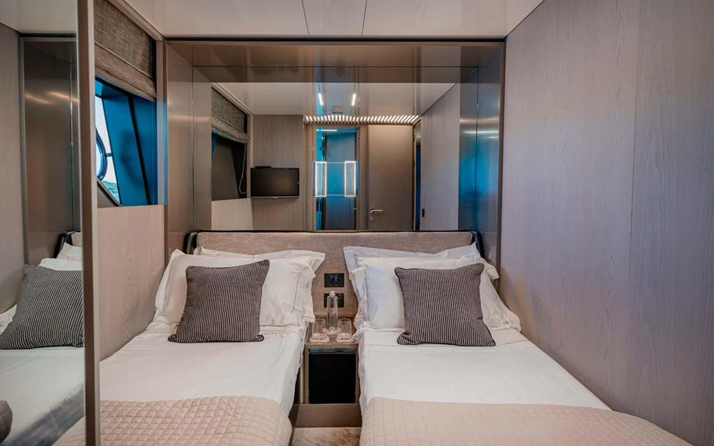 The guest stateroom features twin beds with plush bedding and modern decor. aboard E3 Yacht for Sale