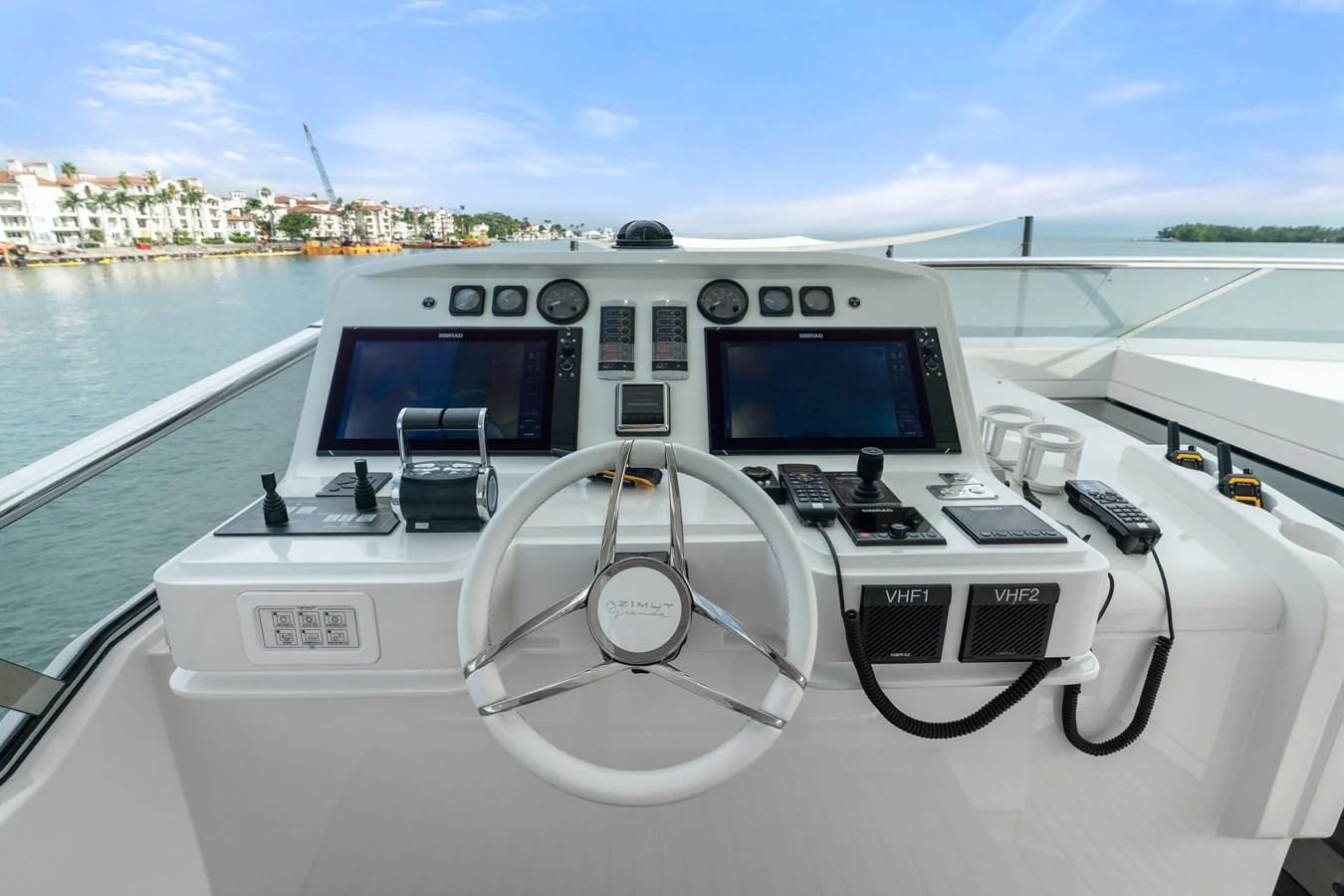 The helm station offers a modern and well-equipped control center with dual screens and a sleek steering wheel. aboard AZIMUT GRANDE 32/23 Yacht for Sale