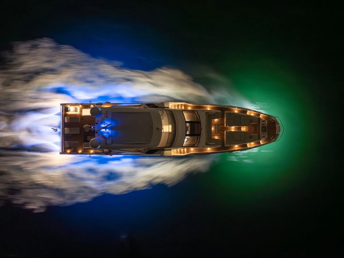 A stunning aerial view of a yacht cruising at night, illuminated by vibrant underwater lights. aboard AZIMUT GRANDE 32/23 Yacht for Sale