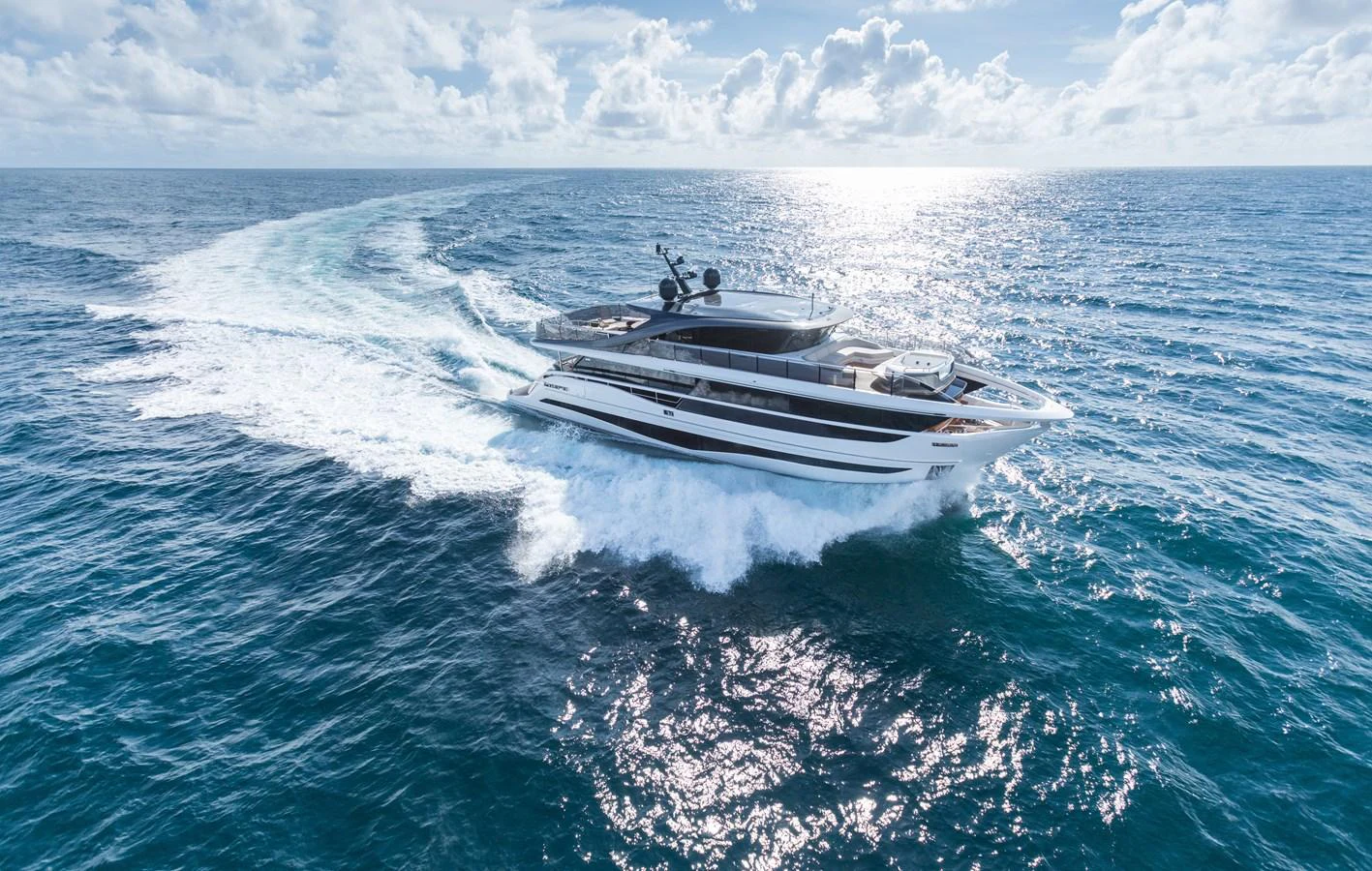 A sleek yacht cruises through the open sea, leaving a trail of white foam in its wake. aboard PRINCESS X95 VISTA Yacht for Sale