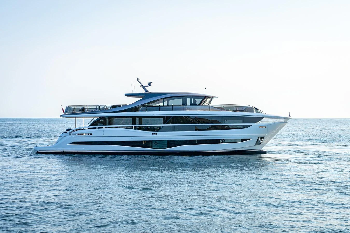 A sleek, modern yacht glides gracefully on calm waters under a clear sky. aboard PRINCESS X95 VISTA Yacht for Sale