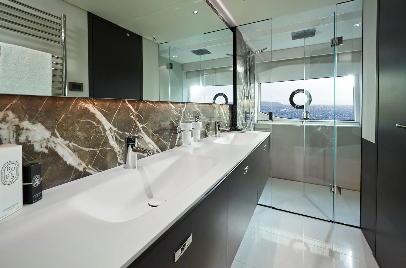 The yacht's bathroom features a sleek design with double sinks and a spacious glass-enclosed shower. aboard PRINCESS X95 VISTA Yacht for Sale