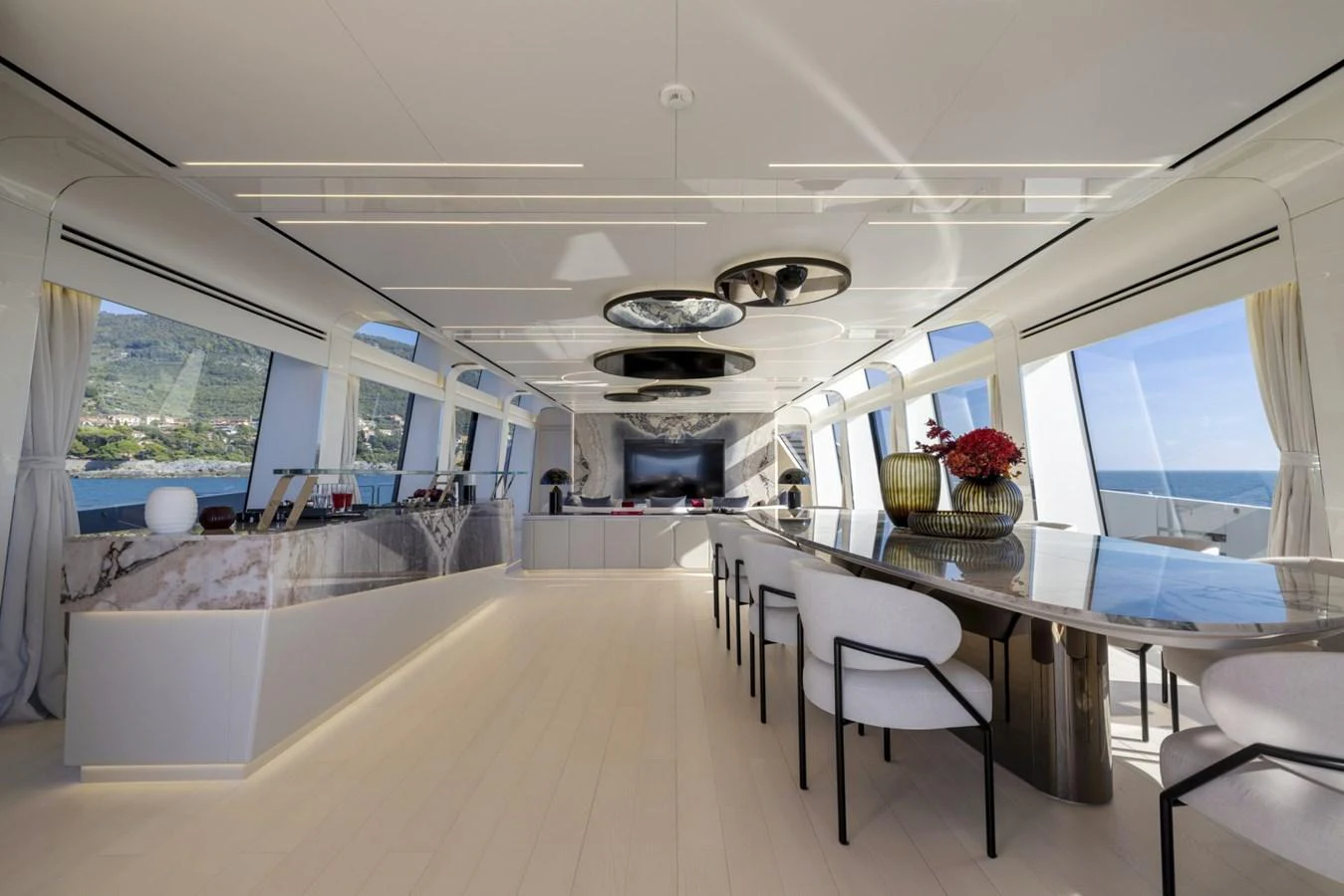 The yacht's dining area features a sleek, modern design with panoramic windows offering stunning sea views. aboard REBELLIOUS Yacht for Sale