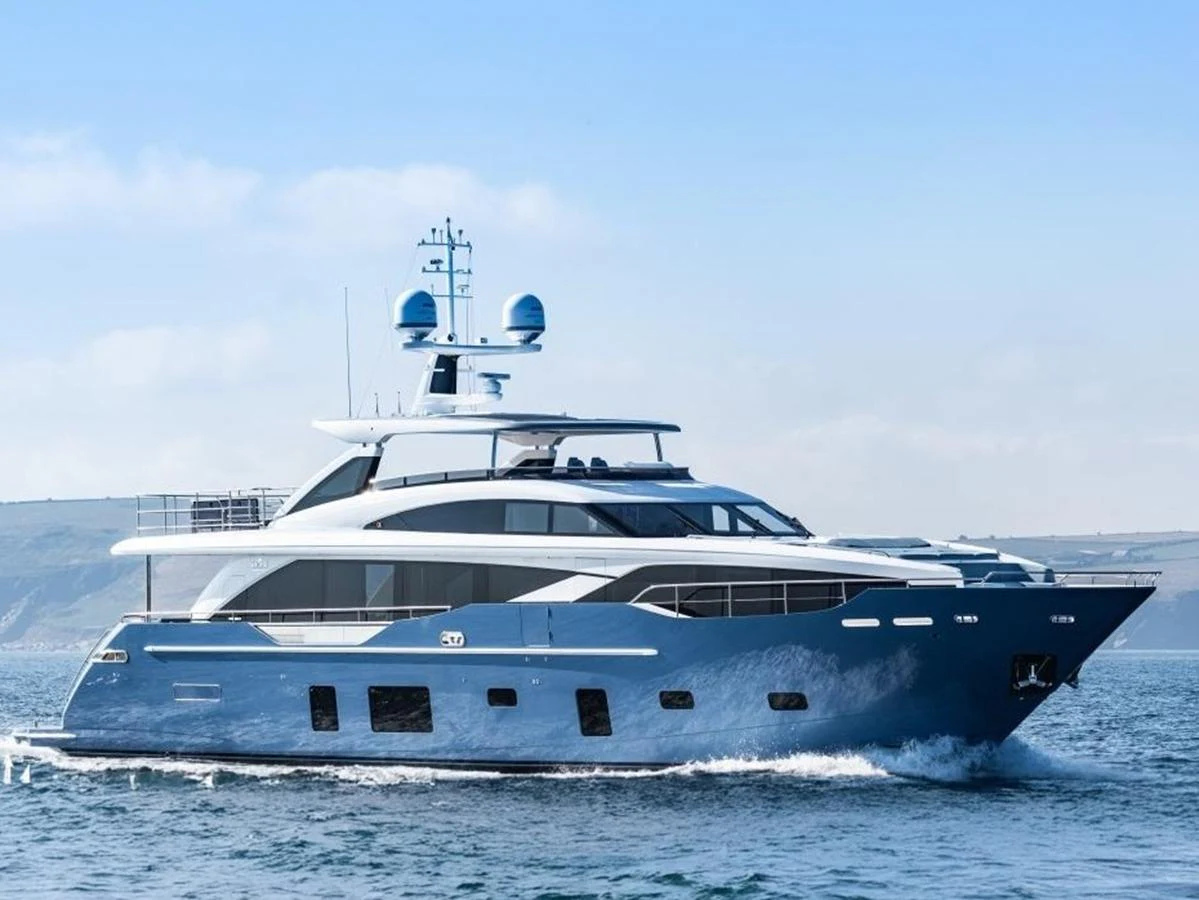 A sleek and modern yacht cruising on calm waters under a clear sky. aboard ADROMELIA Yacht for Sale