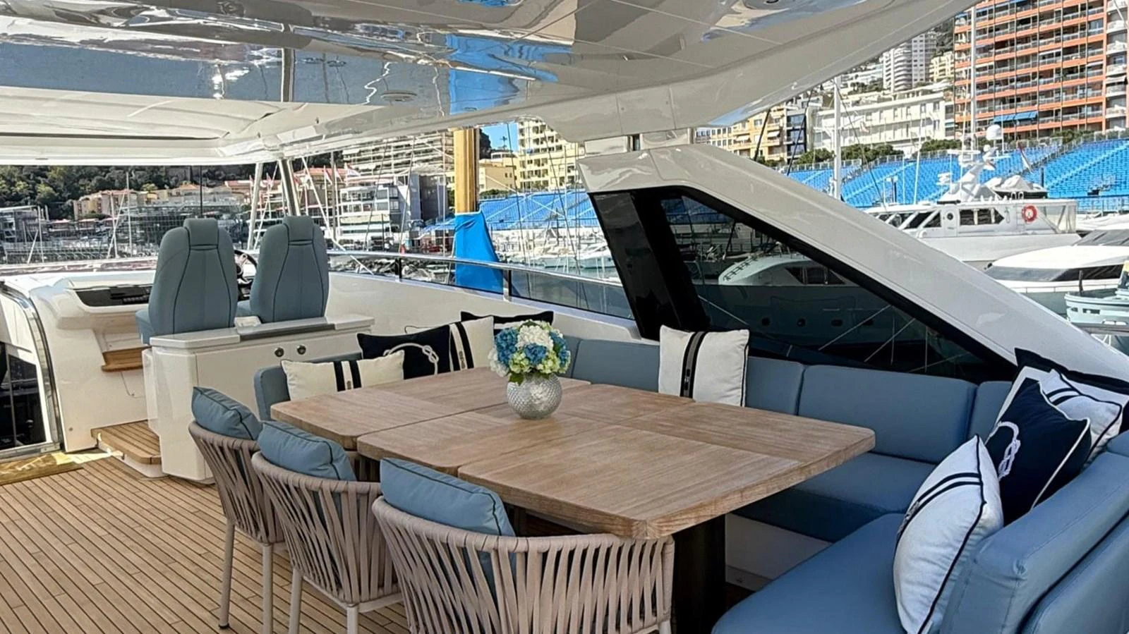The aft deck features a stylish dining area with comfortable seating and a wooden table, perfect for alfresco dining. aboard ADROMELIA Yacht for Sale