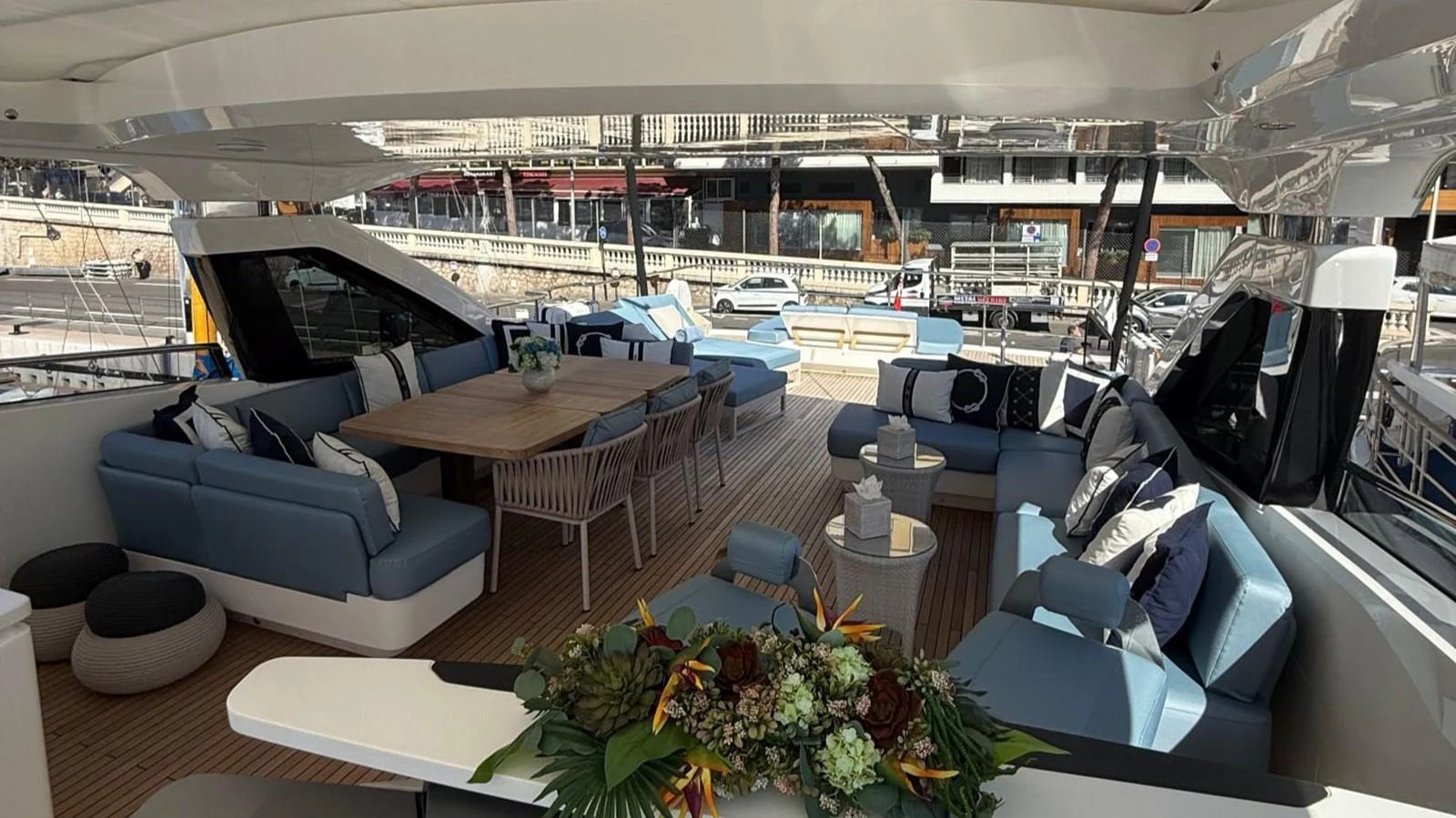 The aft deck features a spacious seating area with plush cushions and a large dining table, perfect for alfresco dining and relaxation. aboard ADROMELIA Yacht for Sale