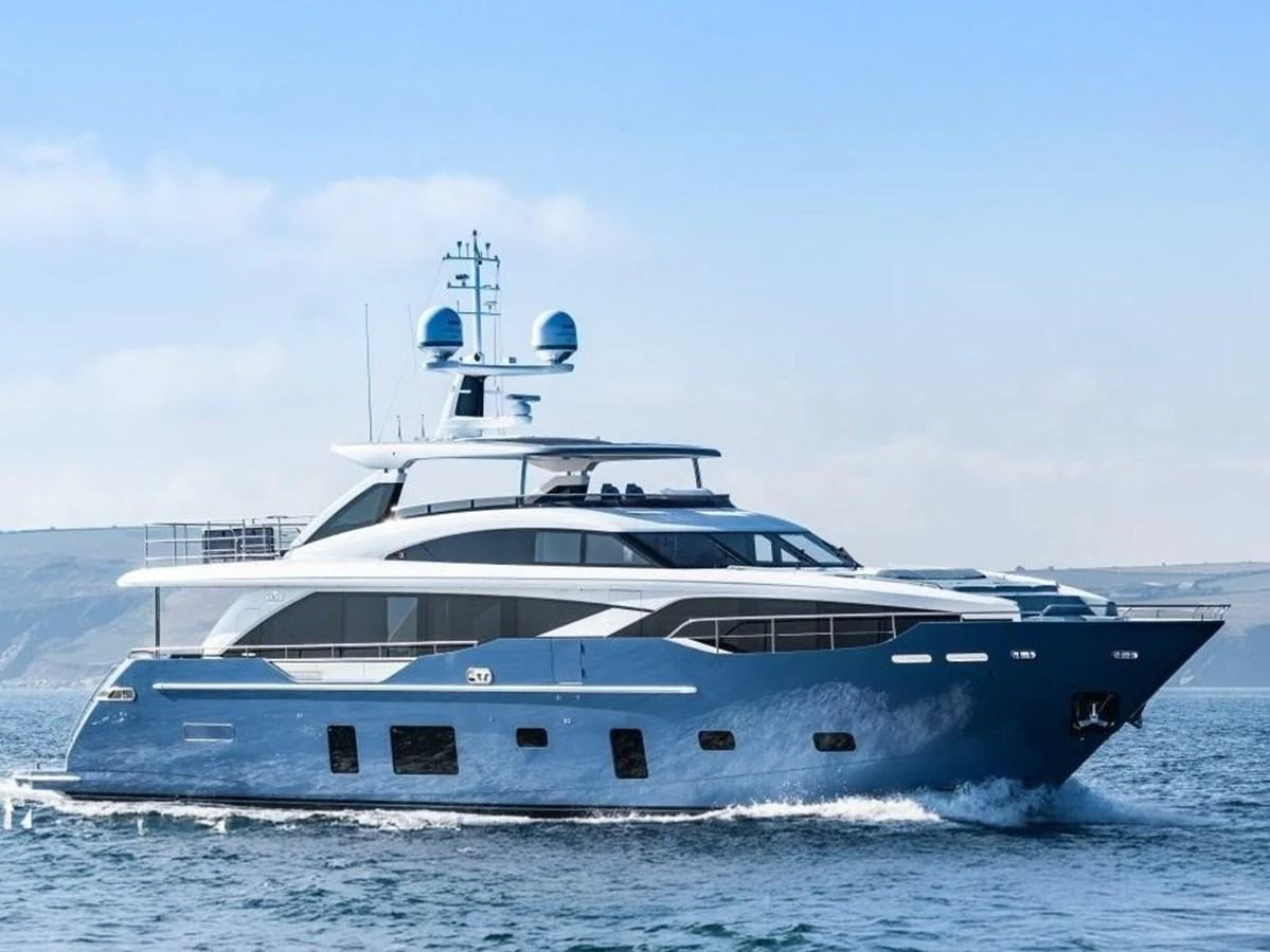 A sleek and modern yacht cruising on calm waters with a scenic backdrop. aboard ADROMELIA Yacht for Sale
