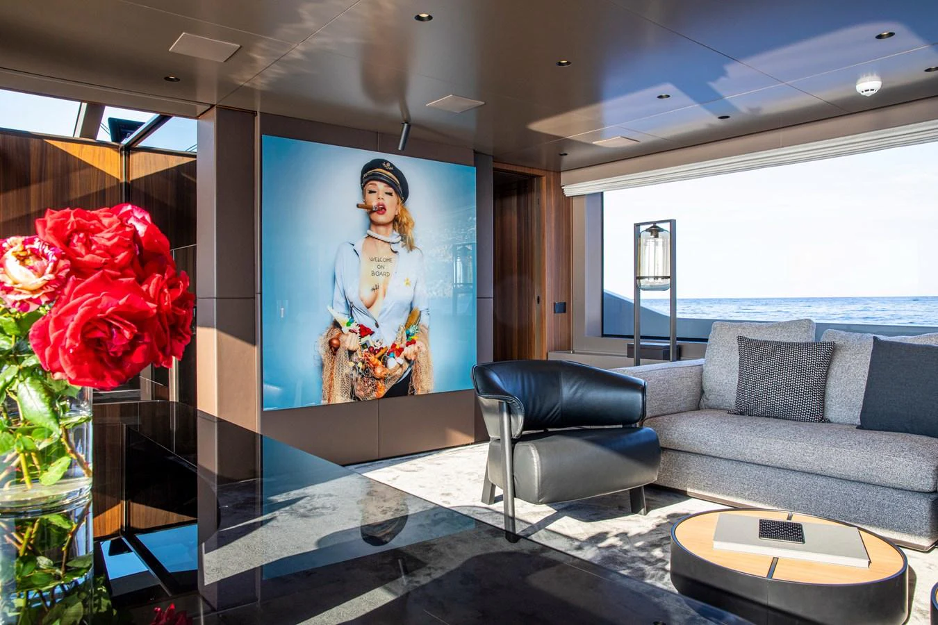 The yacht's interior features a stylish and modern living area with a large window offering a view of the sea. aboard SEVEN Yacht for Sale