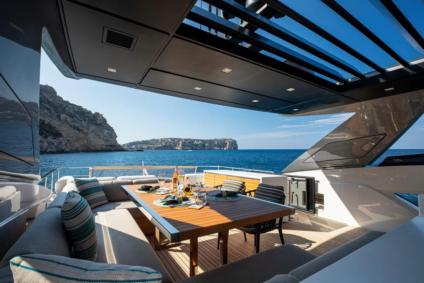 The aft deck features a luxurious outdoor dining area with stunning ocean views. aboard SEVEN Yacht for Sale