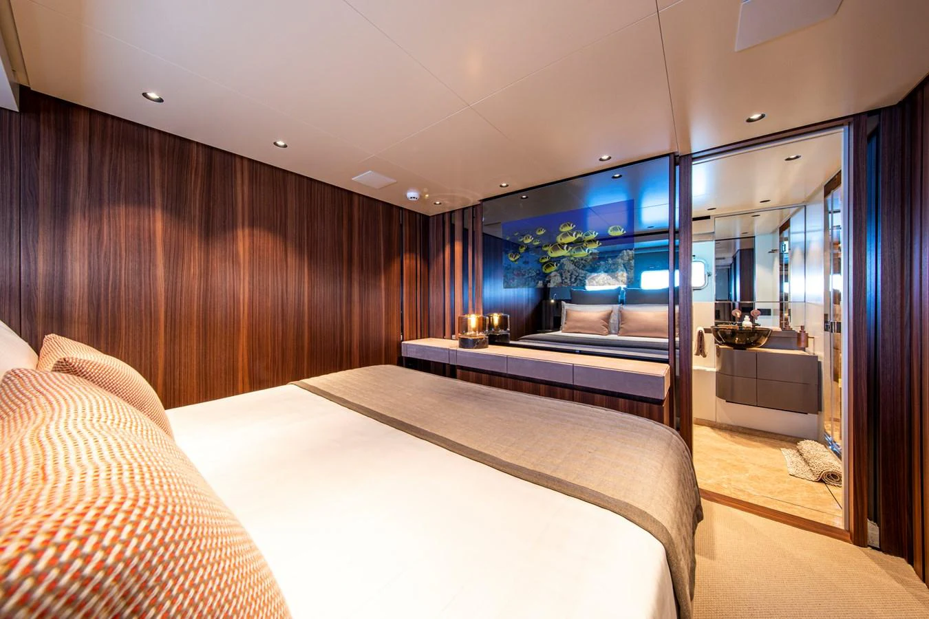The stateroom features a luxurious bed with rich wood paneling and an ensuite bathroom. aboard SEVEN Yacht for Sale
