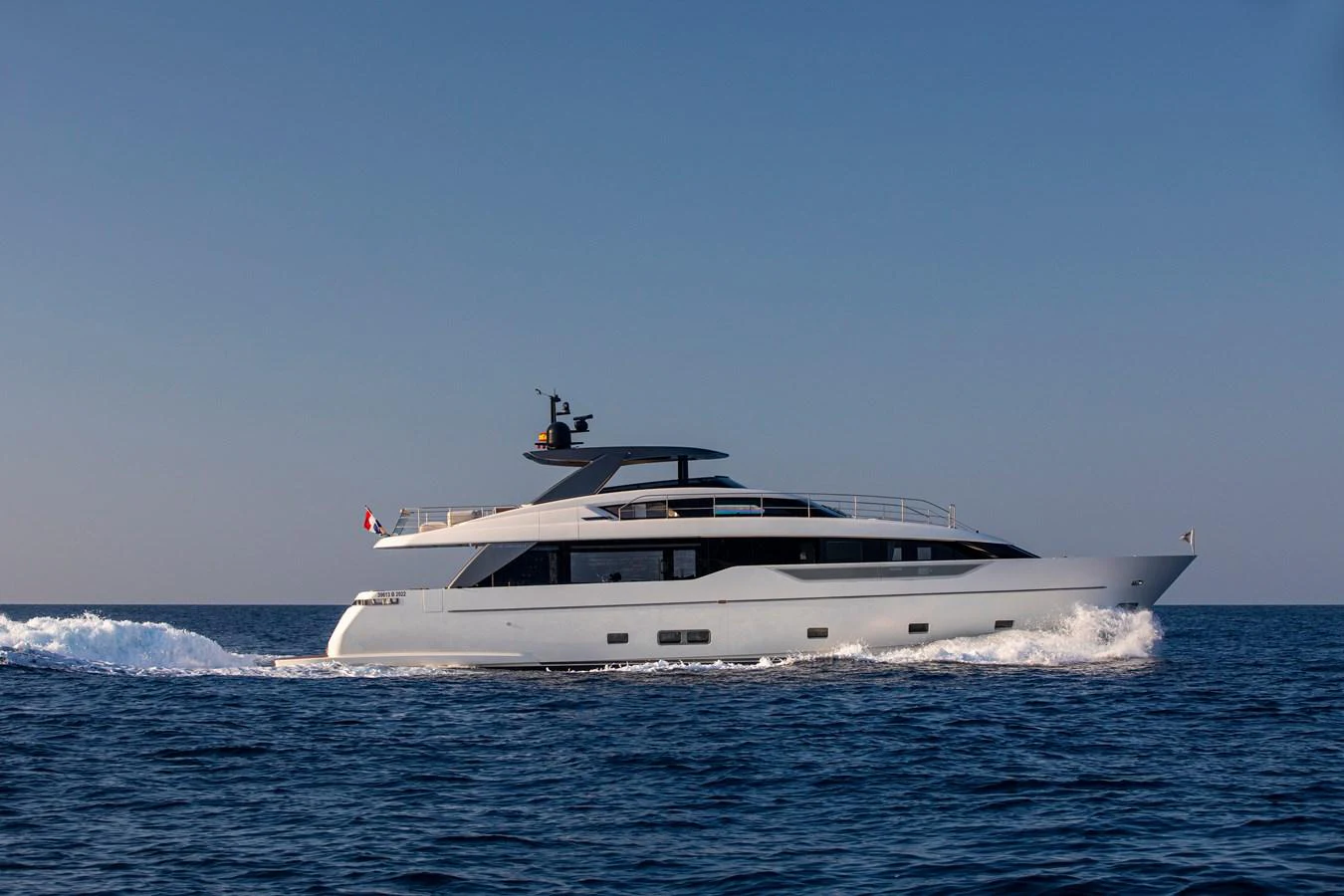 A sleek and modern yacht glides effortlessly across the calm blue sea. aboard SEVEN Yacht for Sale