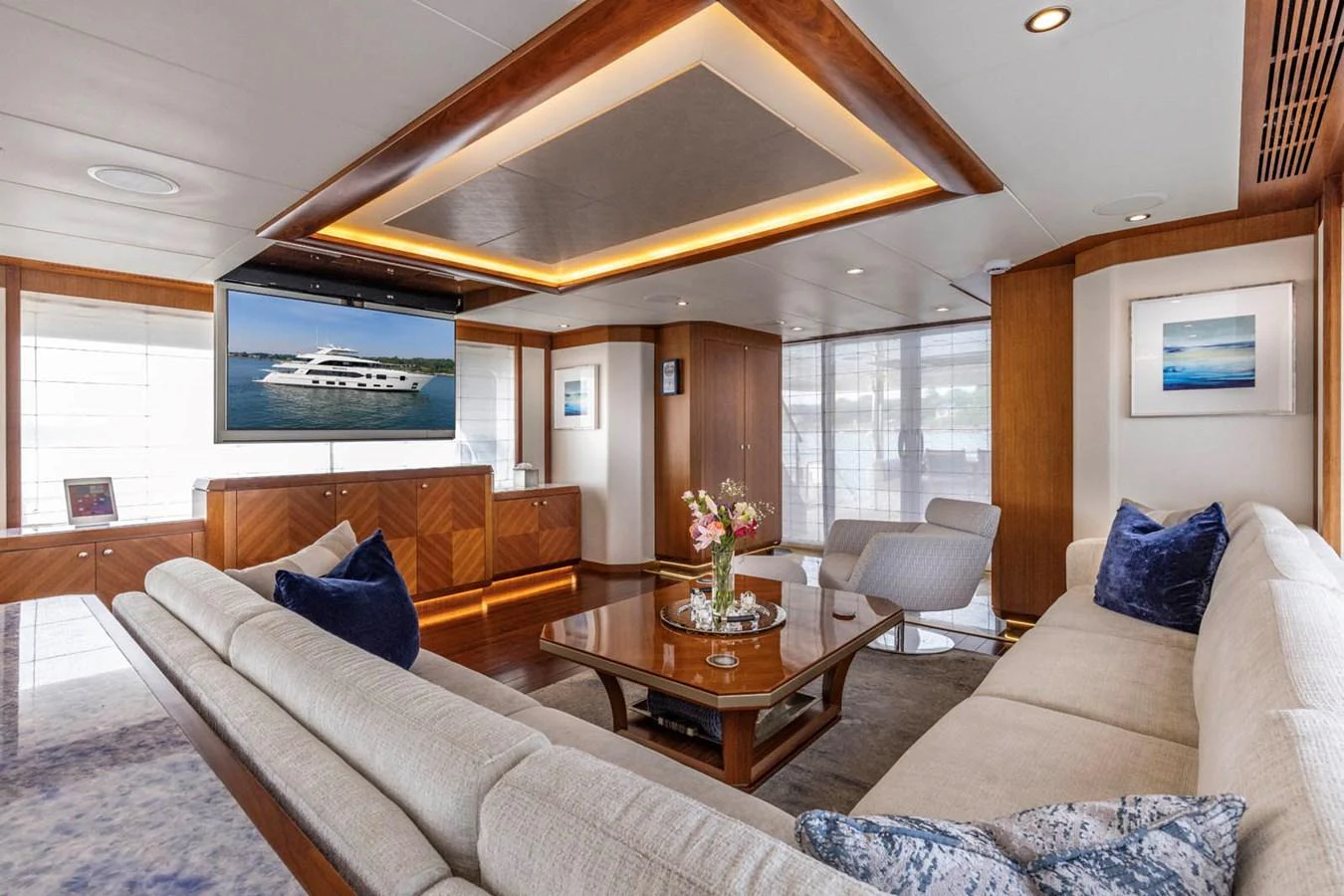 The salon features elegant wood finishes, plush seating, and a large TV for entertainment. aboard WRECKLESS Yacht for Sale