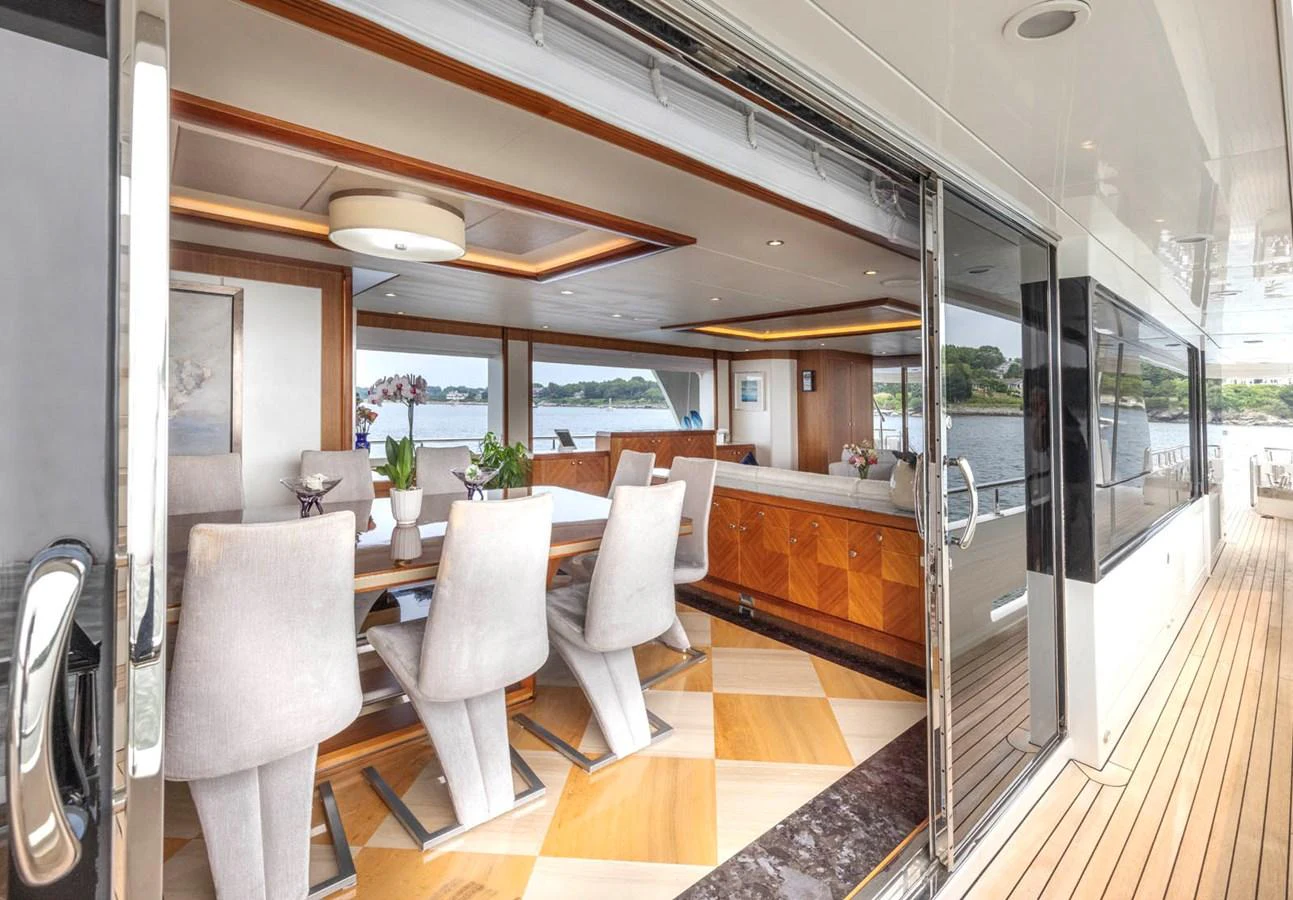 The yacht's dining area features elegant seating and a beautiful view of the water. aboard WRECKLESS Yacht for Sale